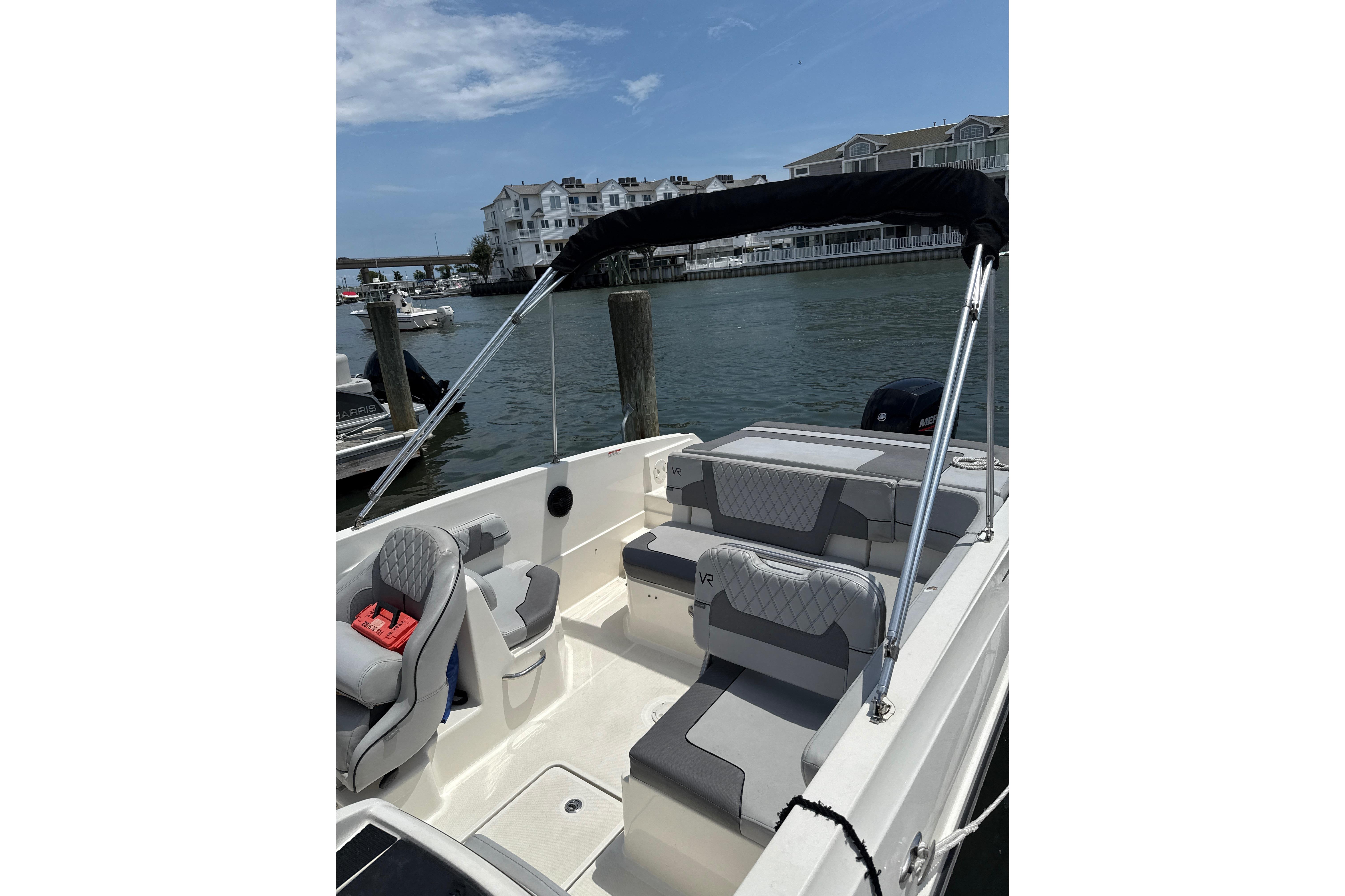 2023 Bayliner VR6 Bowrider OB docked, featuring spacious seating and sleek design.