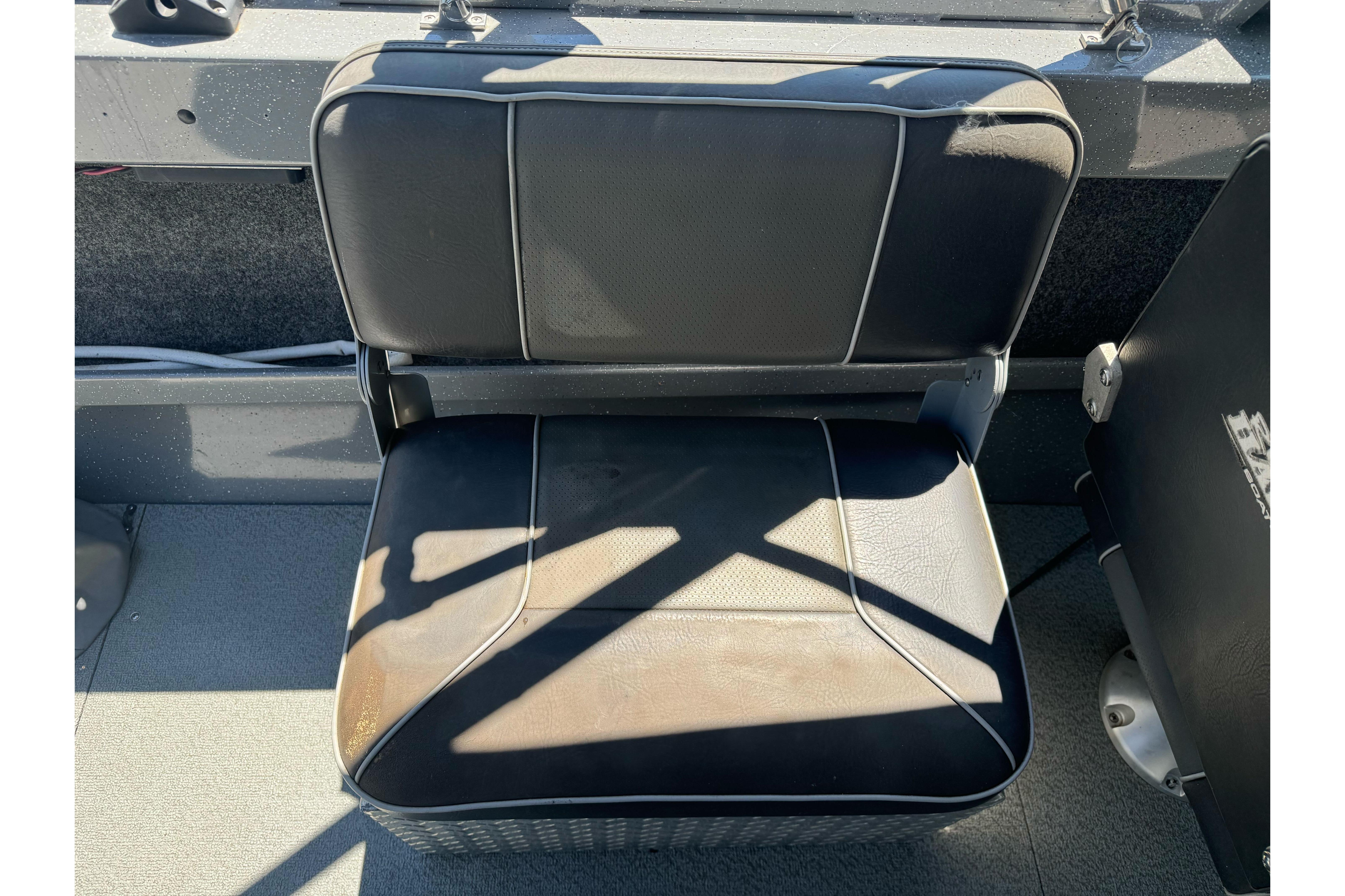 Black seat in a 2014 River Hawk 19 GB boat, sunlight casting shadows.