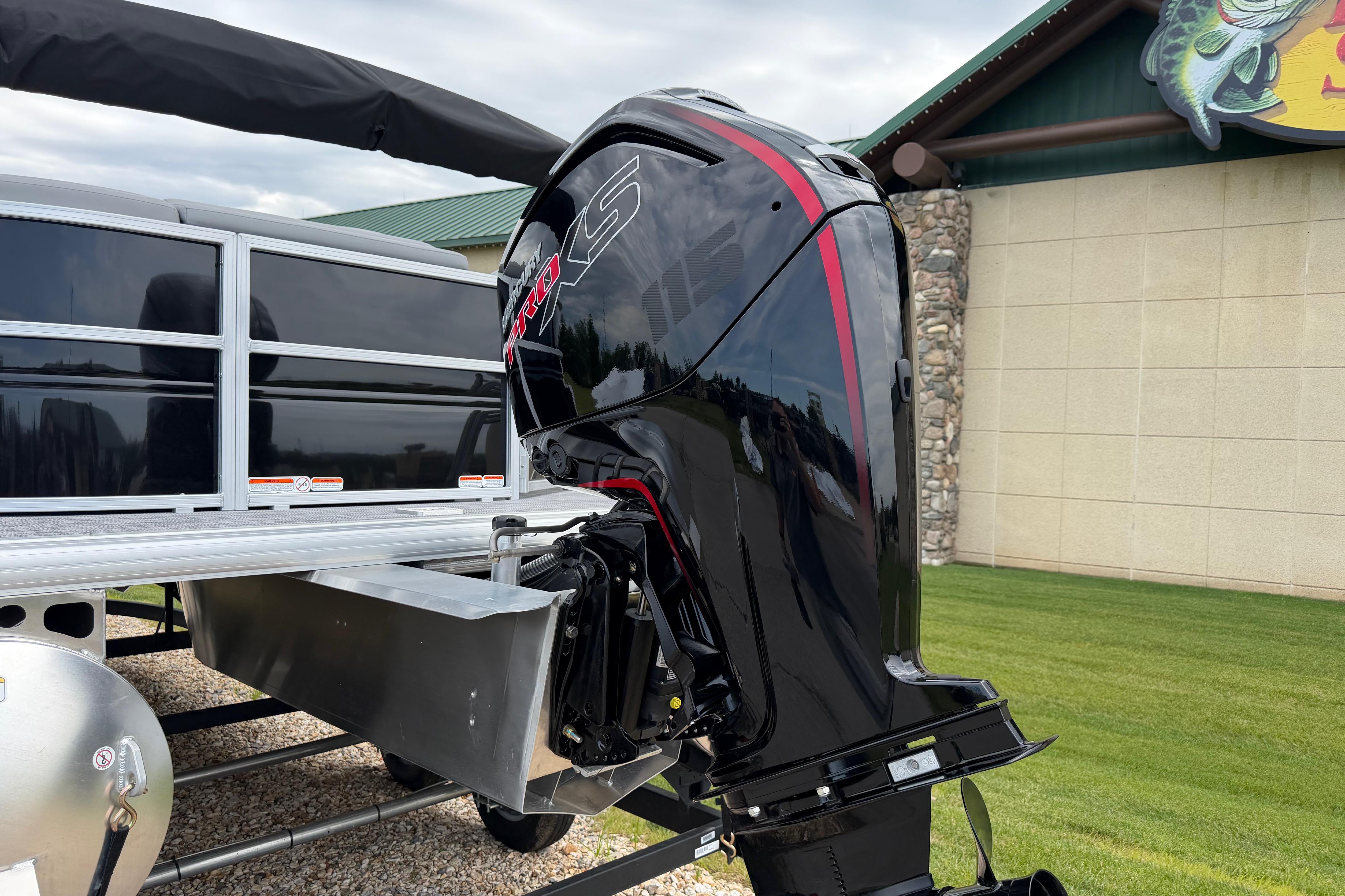 2026 Sun Tracker Party Barge 20 DLX with powerful outboard motor, parked outdoors.