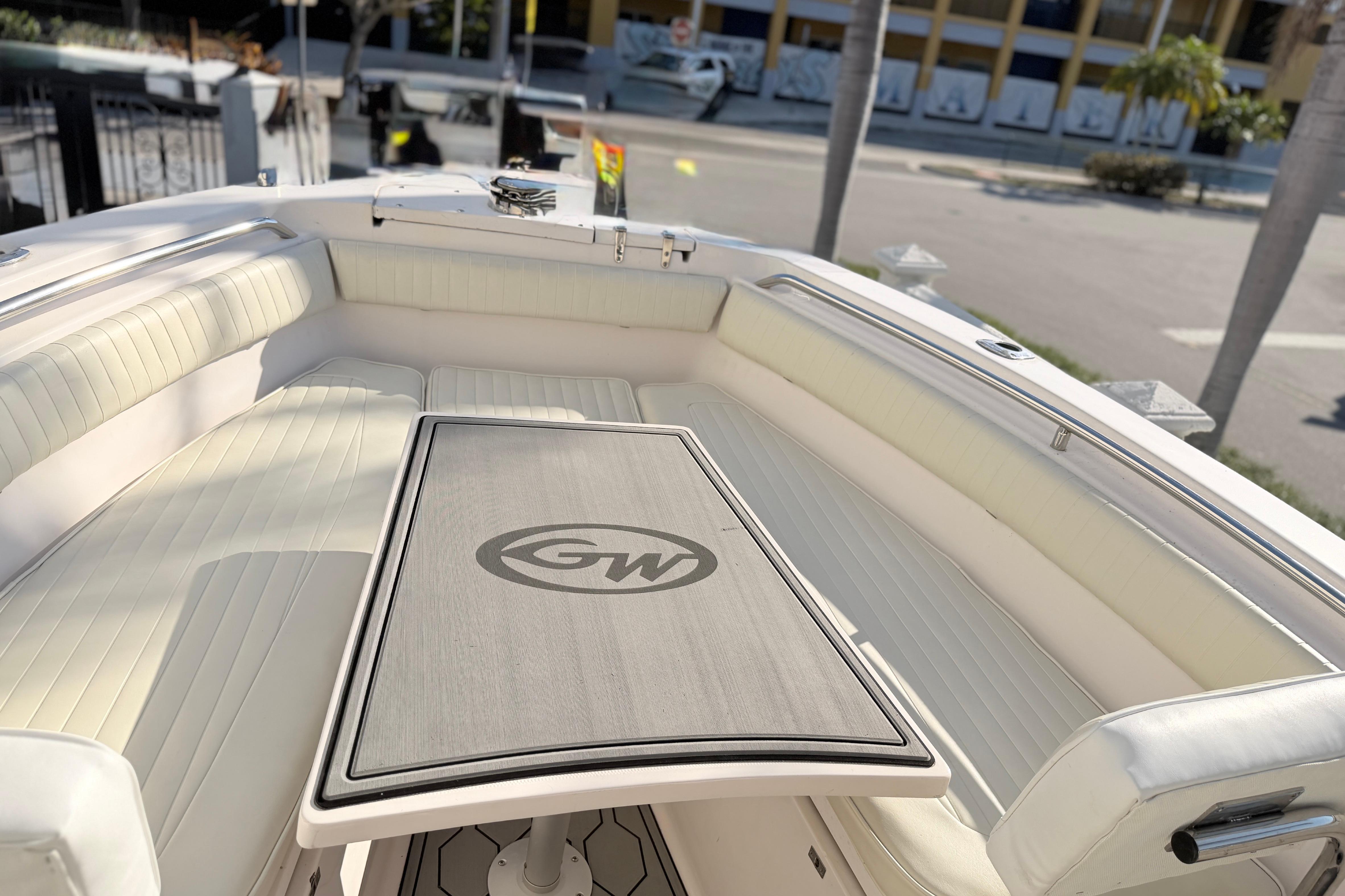 2004 Grady White 273 boat interior with cushioned seating and table, parked in urban setting.