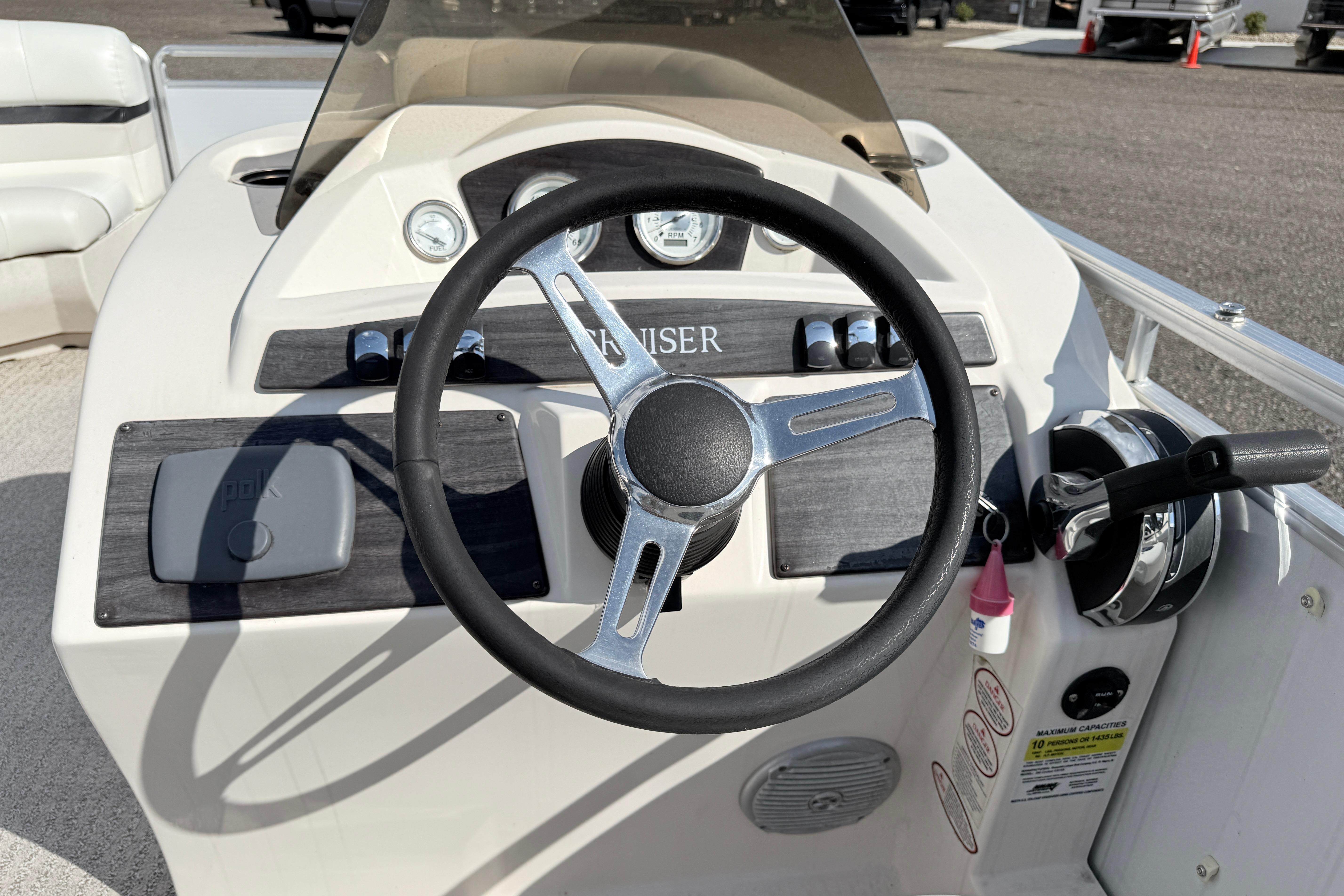 Steering console of a 2014 Harris FloteBote 20 pontoon boat with controls and gauges.