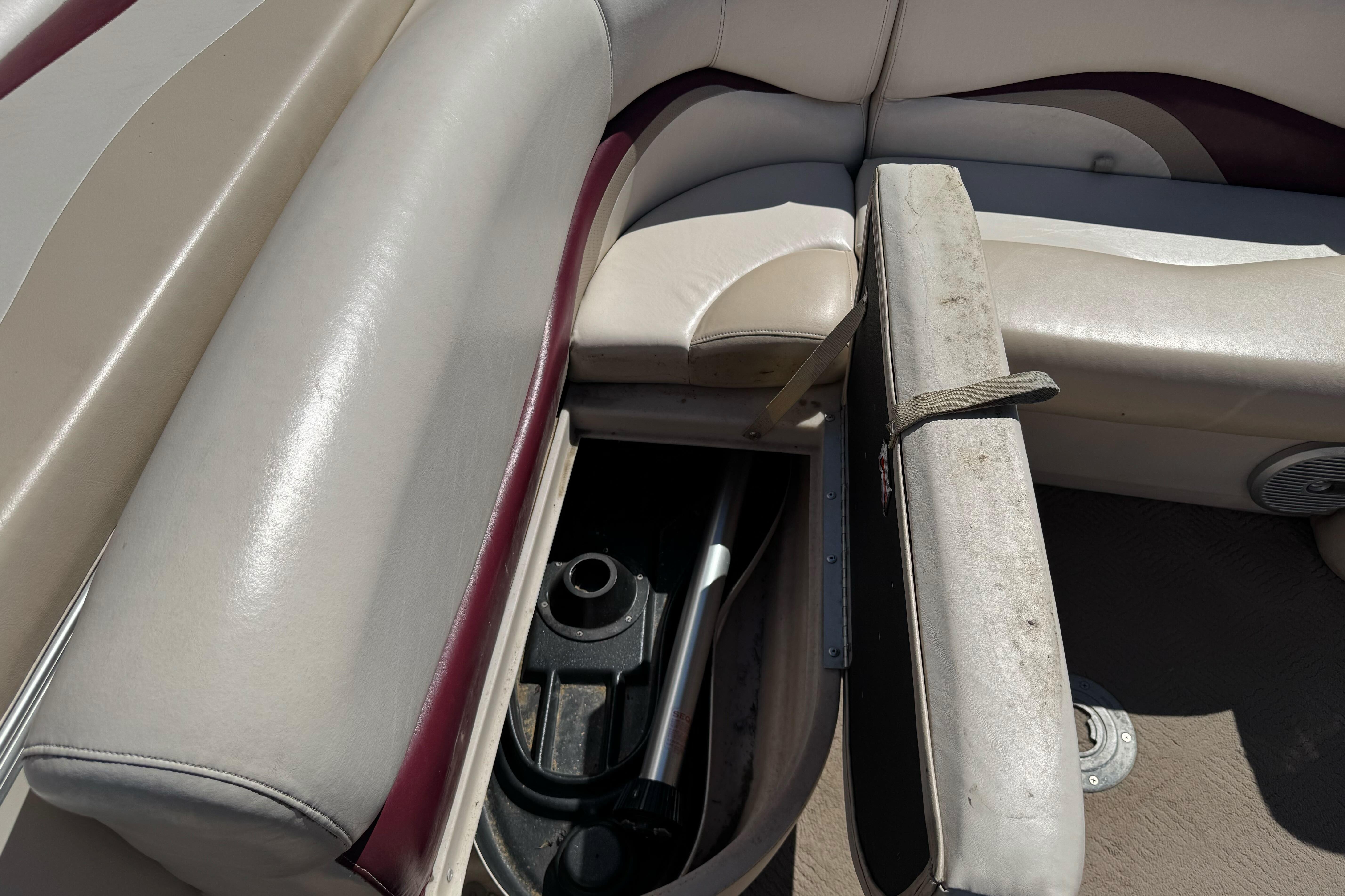 2011 Sun Tracker Party Barge 21 interior storage compartment with beige and maroon seating.