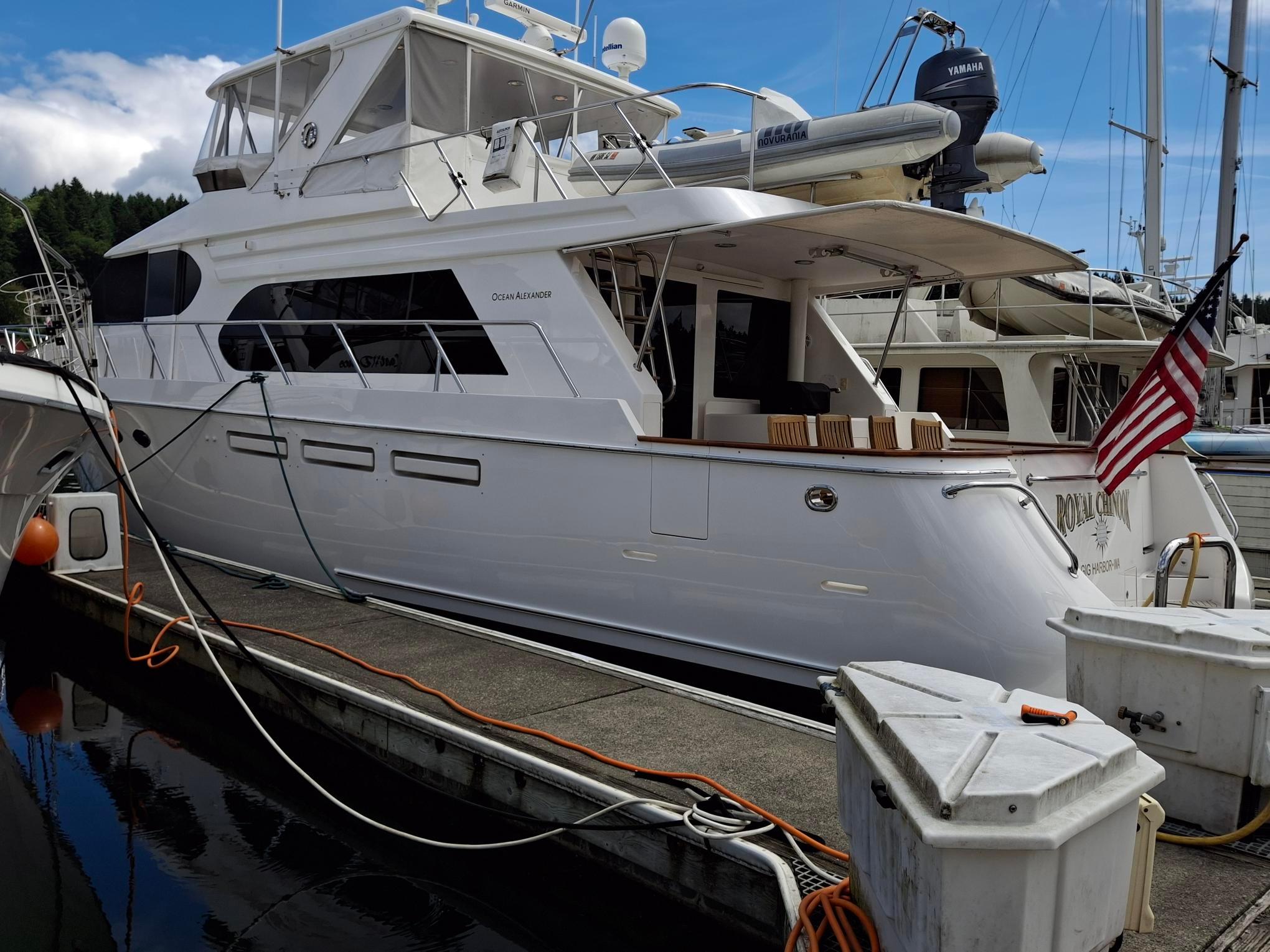 2004 Ocean Alexander 64 Pilothouse yacht docked at marina with American flag.