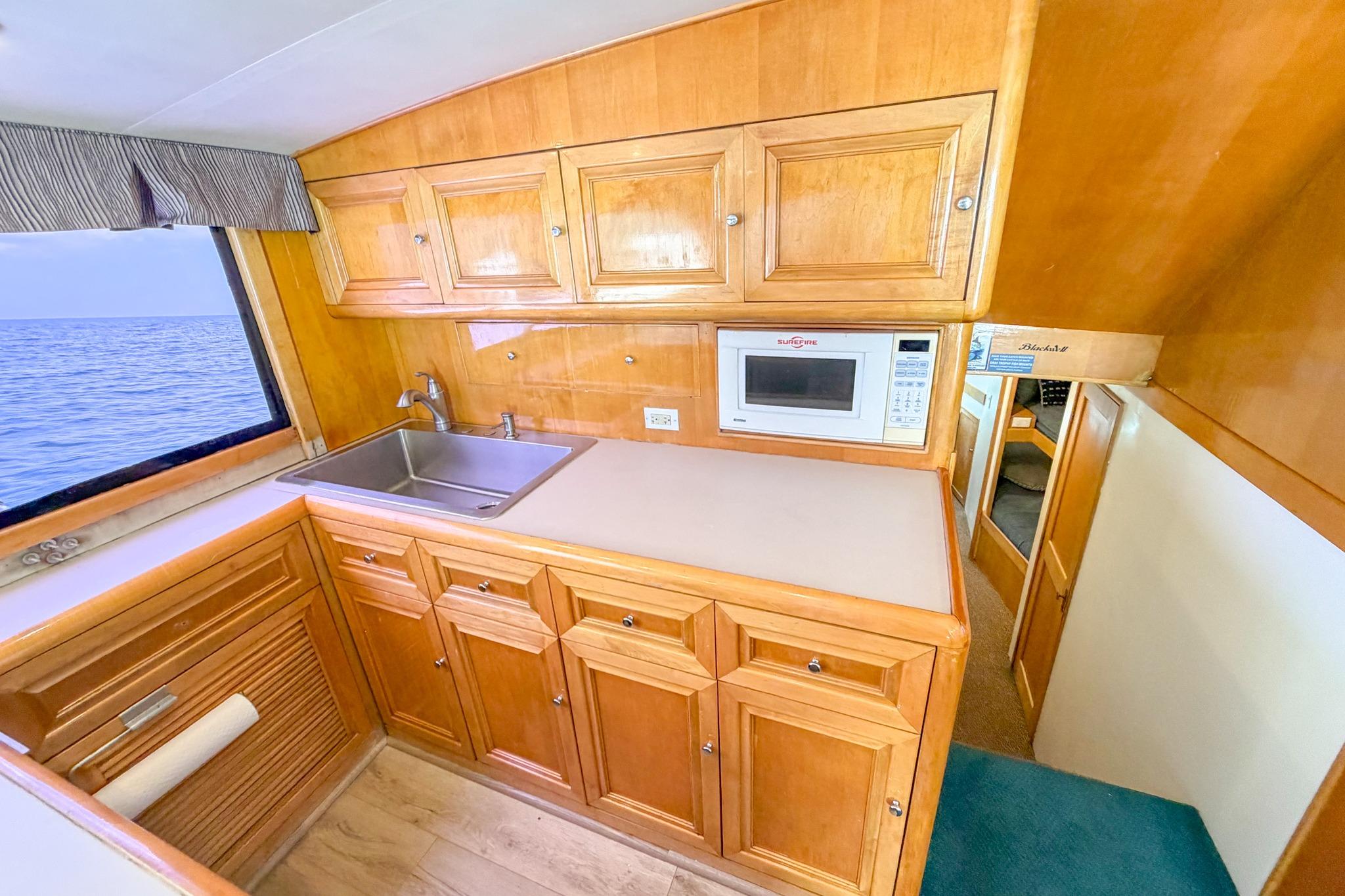 Interior of 1998 Blackwell Custom Carolina Sportfish with wooden cabinetry and ocean view.