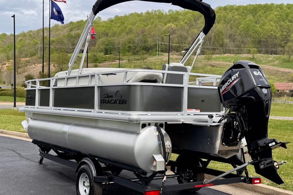 2026 Sun Tracker Bass Buggy 18 DLX pontoon boat with Mercury engine on trailer.