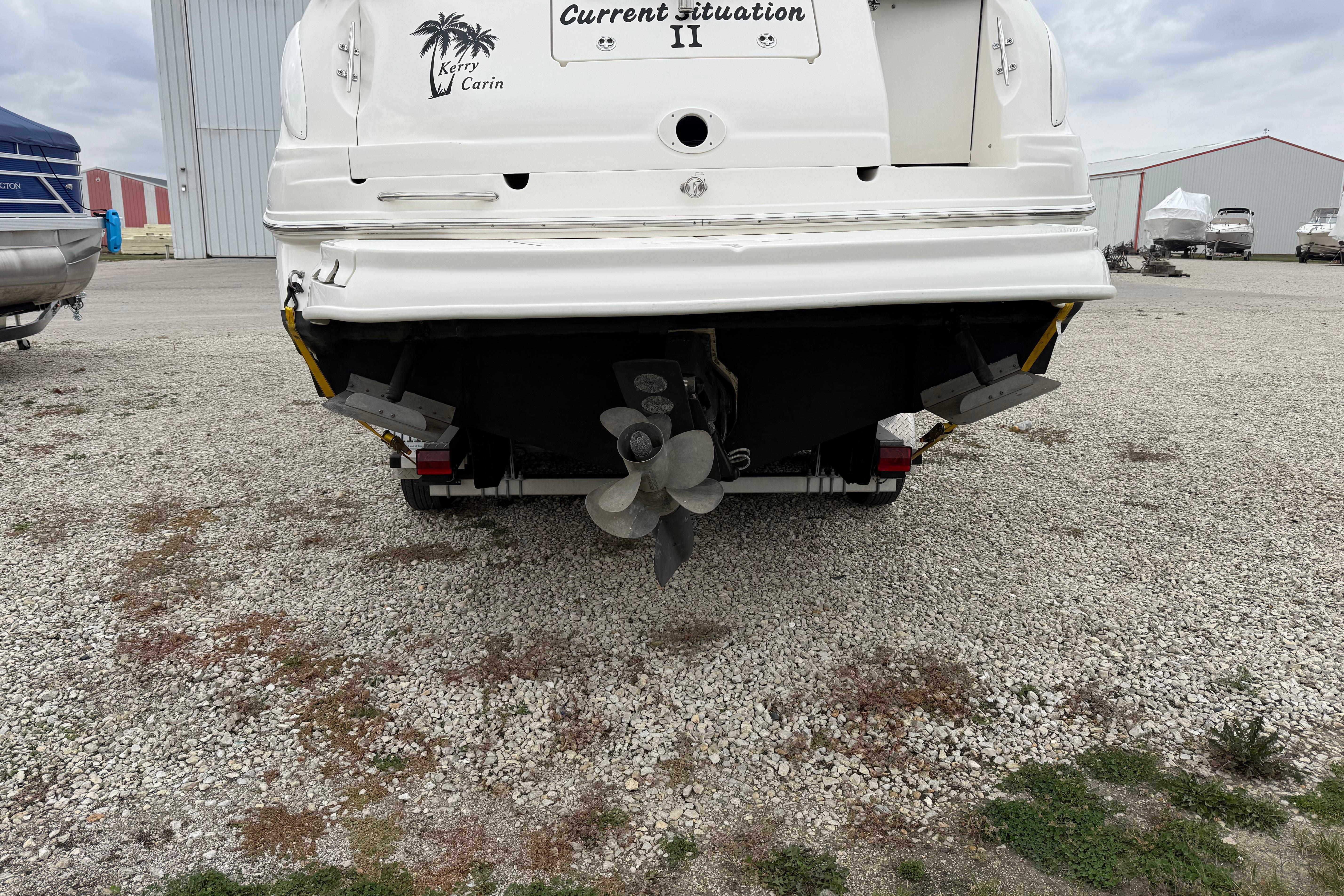 Rear view of a 2004 Sea Ray Sundancer 280 boat on gravel lot.