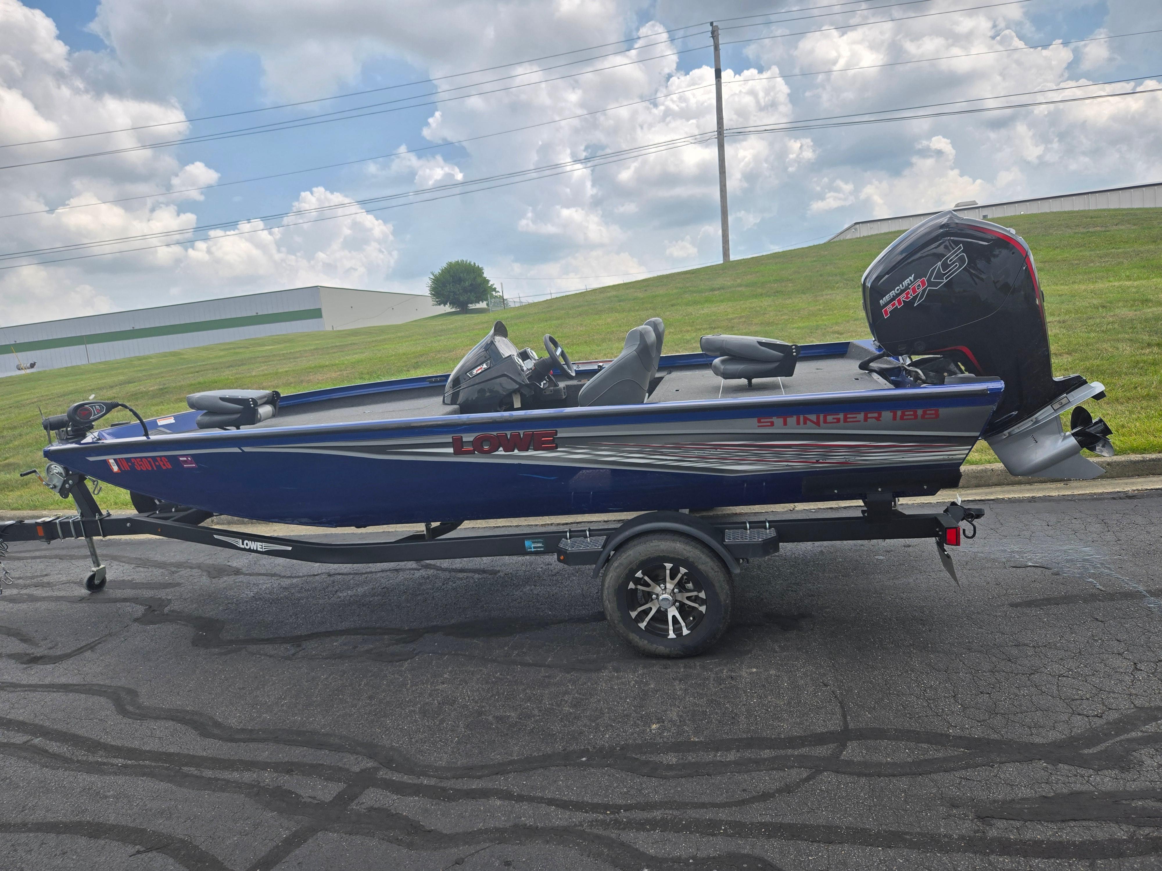 2021 Lowe Stinger 188 boat on trailer, parked outdoors under cloudy sky.