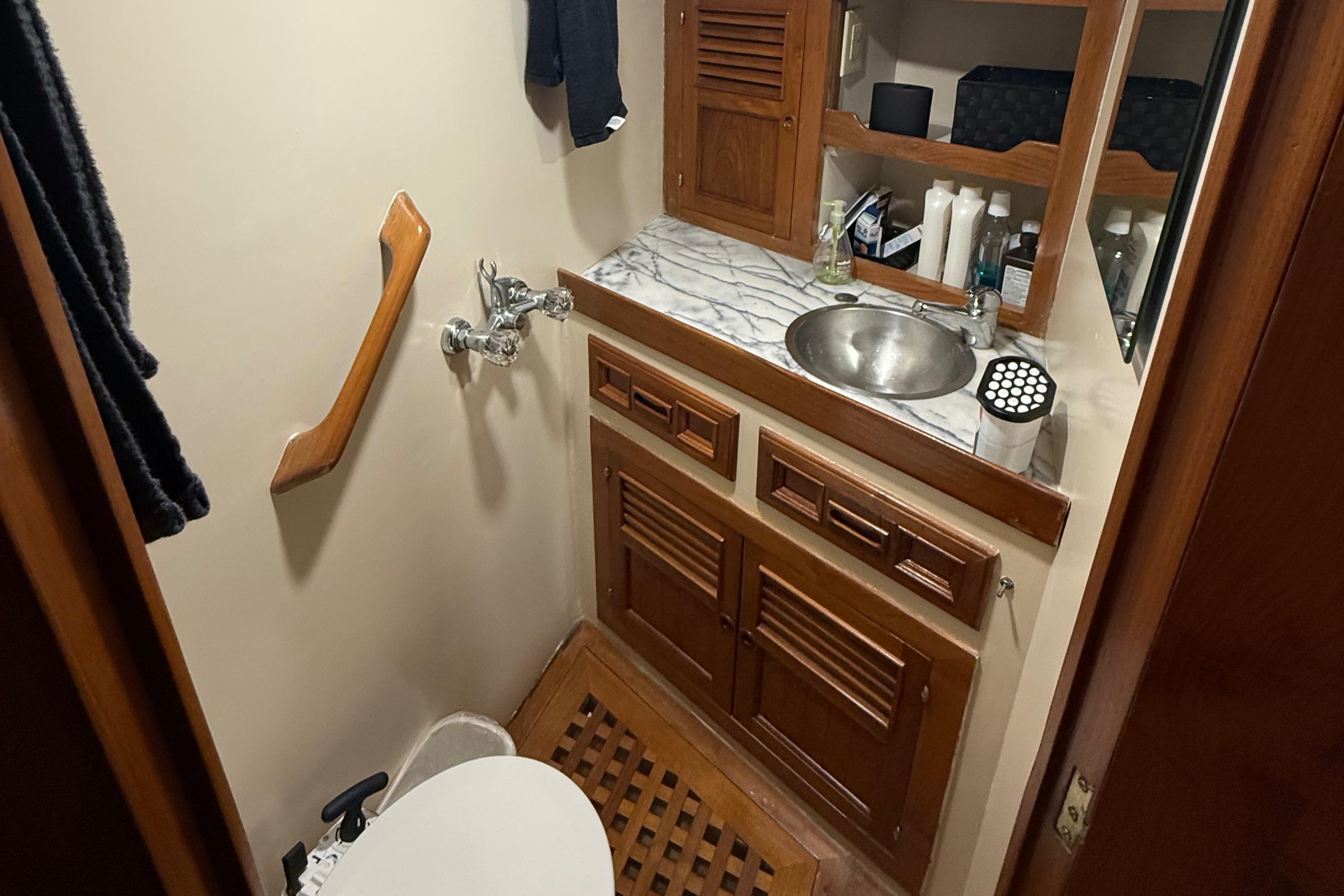 1978 DeFever 39 yacht bathroom with wooden cabinets and marble countertop.