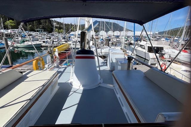 1970 DeFever Passage Maker yacht deck with seating, docked at a marina.