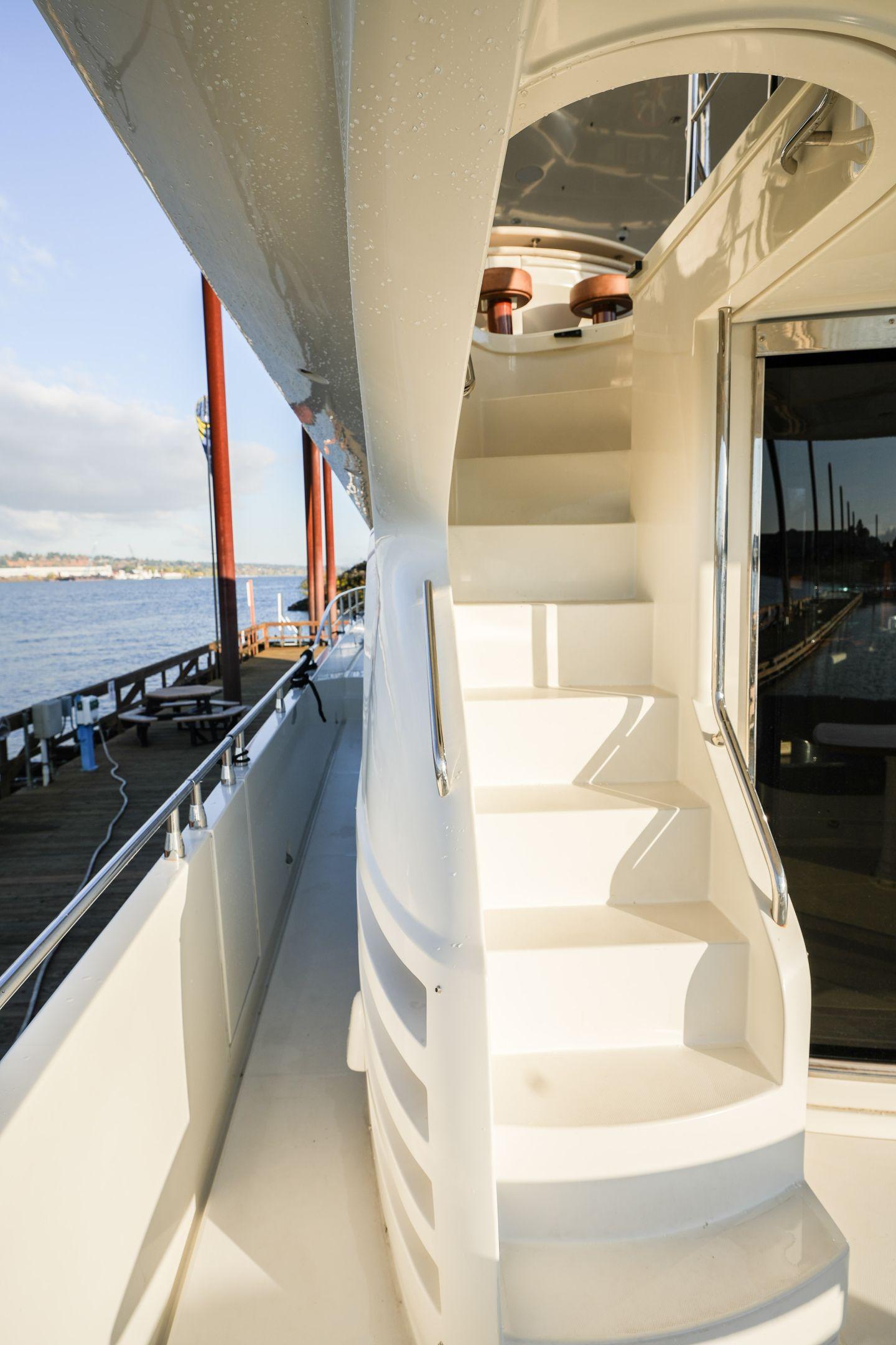 Staircase on a 2006 Marquis 65 yacht, docked by the water.