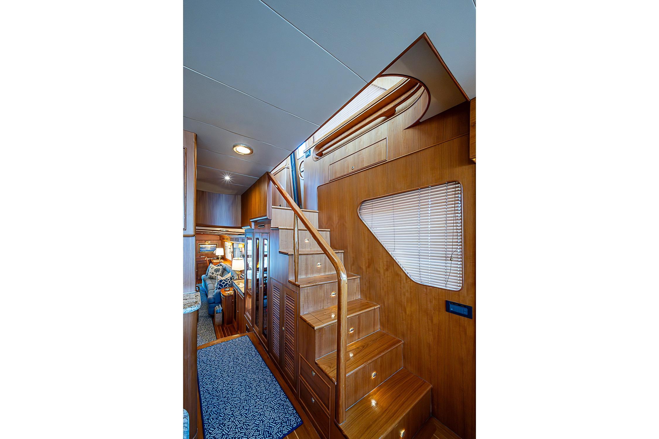 Interior of 2014 Marlow 80 Explorer yacht with wooden staircase and cozy seating area.