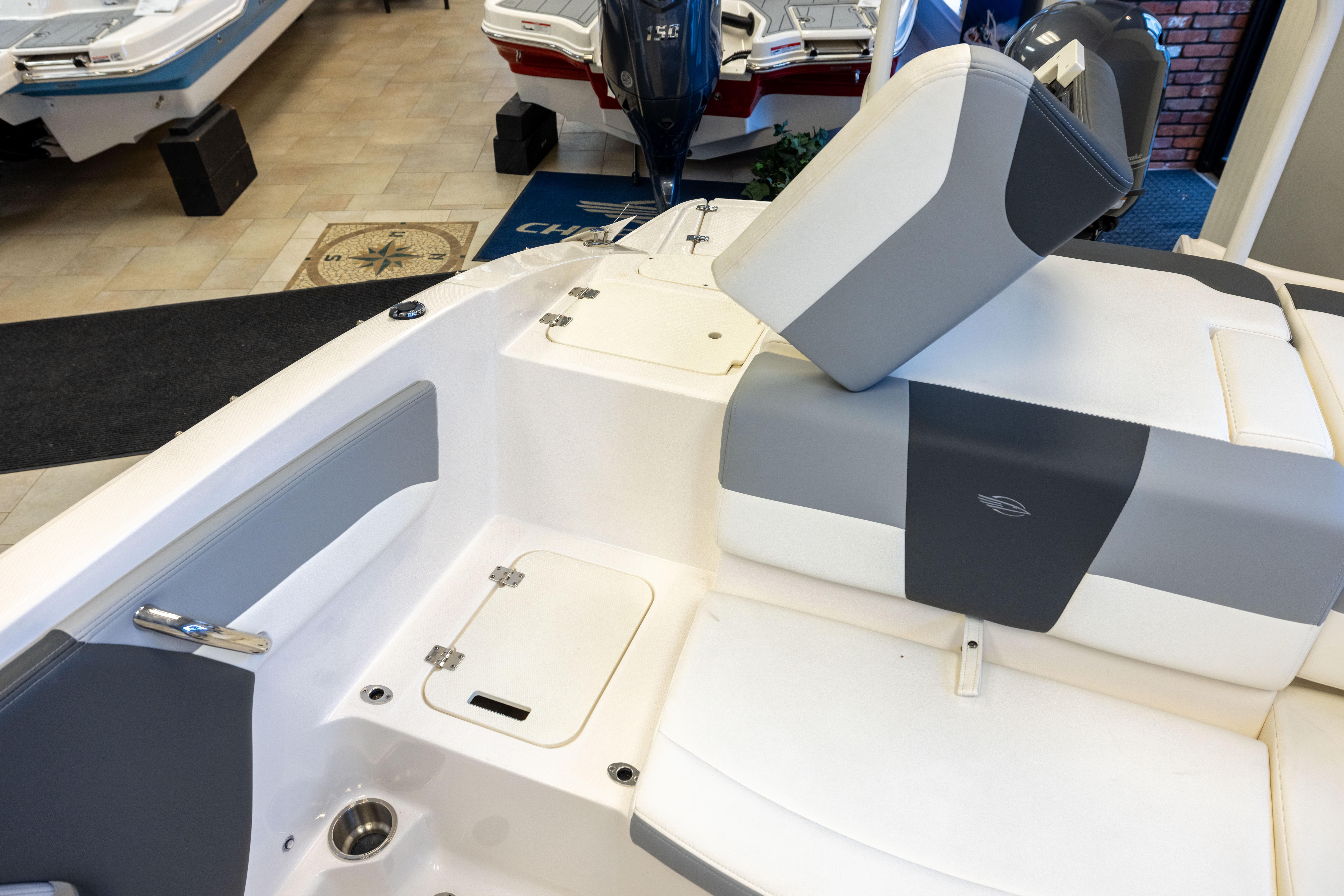 2024 Chaparral 19 SSi OB boat interior with gray and white seating in showroom.