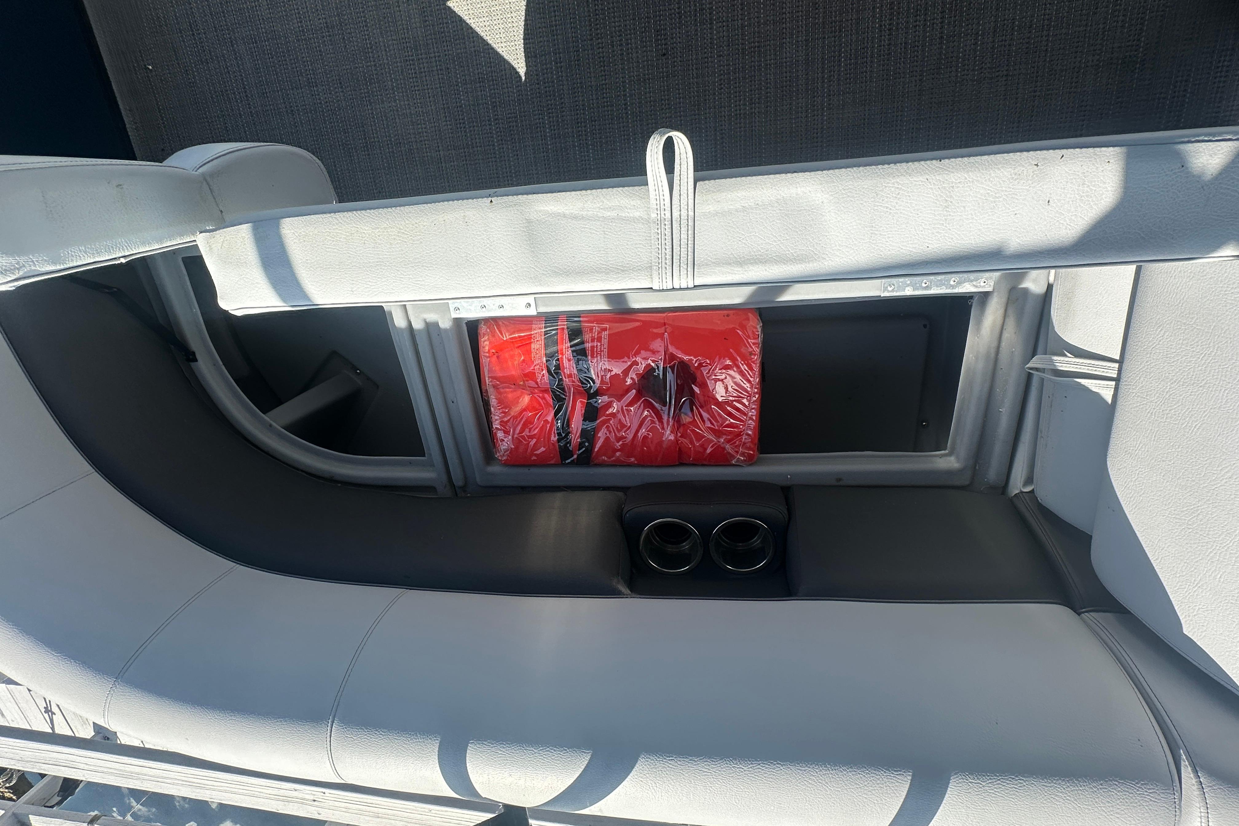 2023 Bentley Pontoons Legacy 243 Swingback interior storage with red life jacket and cup holders.
