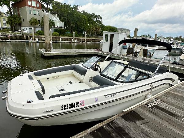 2022 Bayliner DX 2050 boat docked at a marina, featuring sleek design and spacious seating.