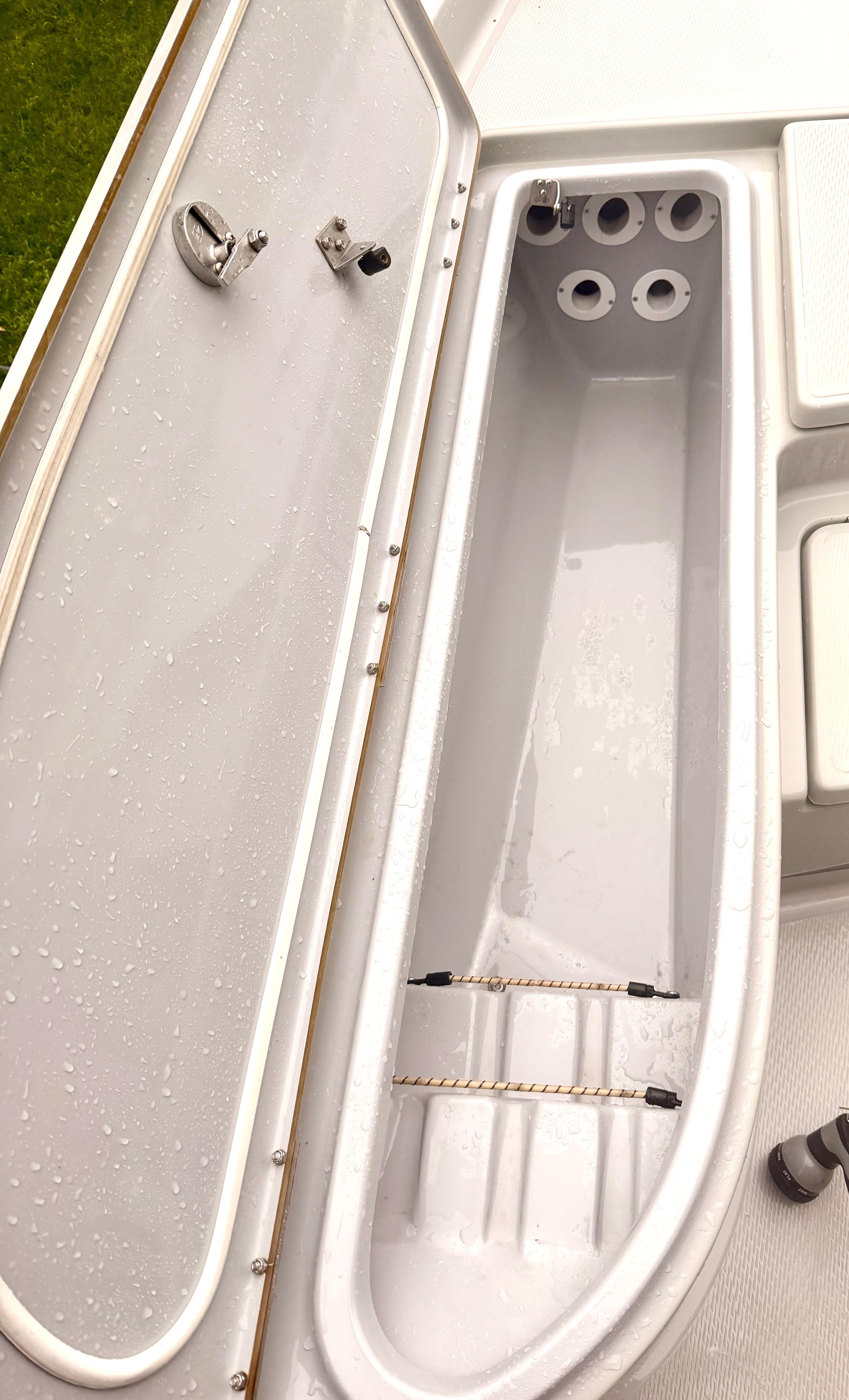 An open storage compartment on a boat with multiple holders.