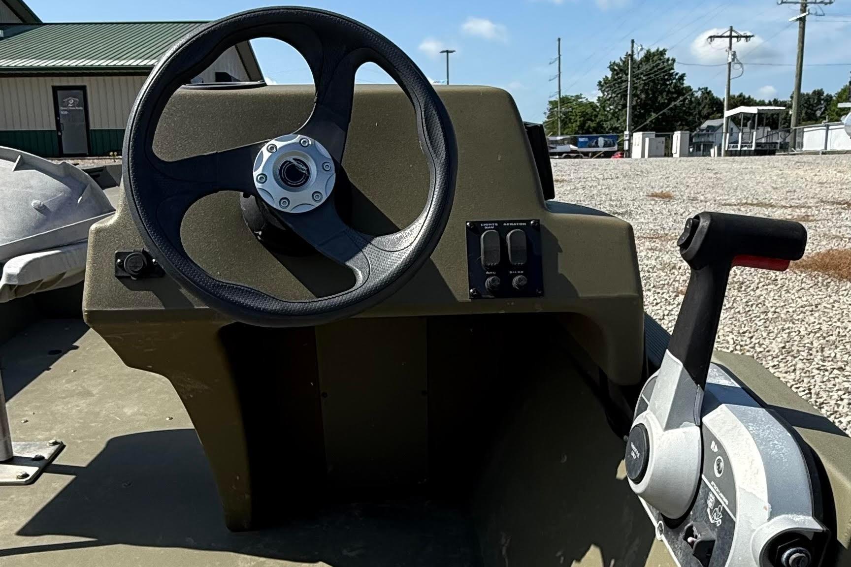 2019 Tracker Grizzly 1648 SC boat steering console with controls, outdoors.