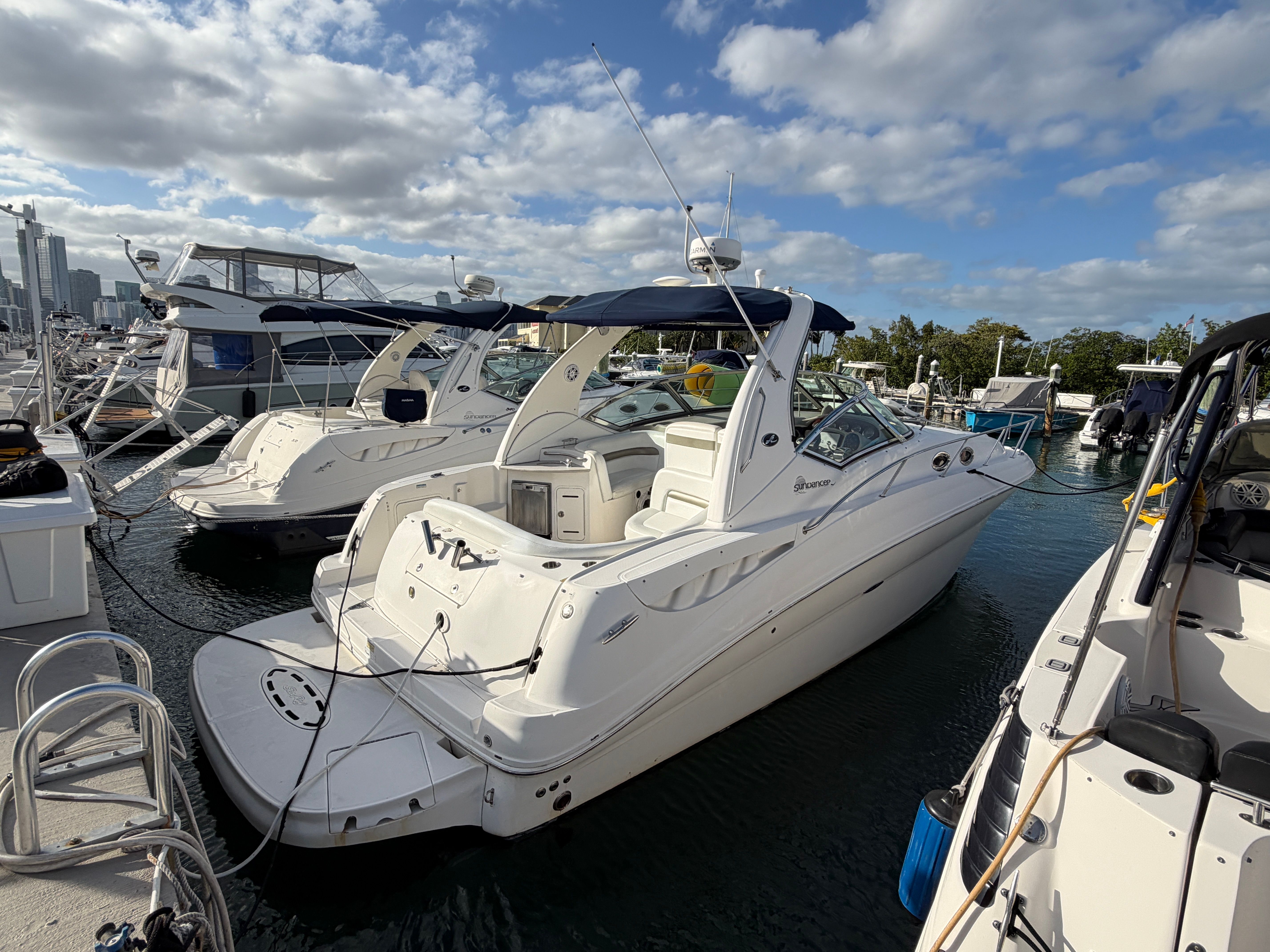 A 2006 Sea Ray Sundancer 320 docked under a sunny sky.
