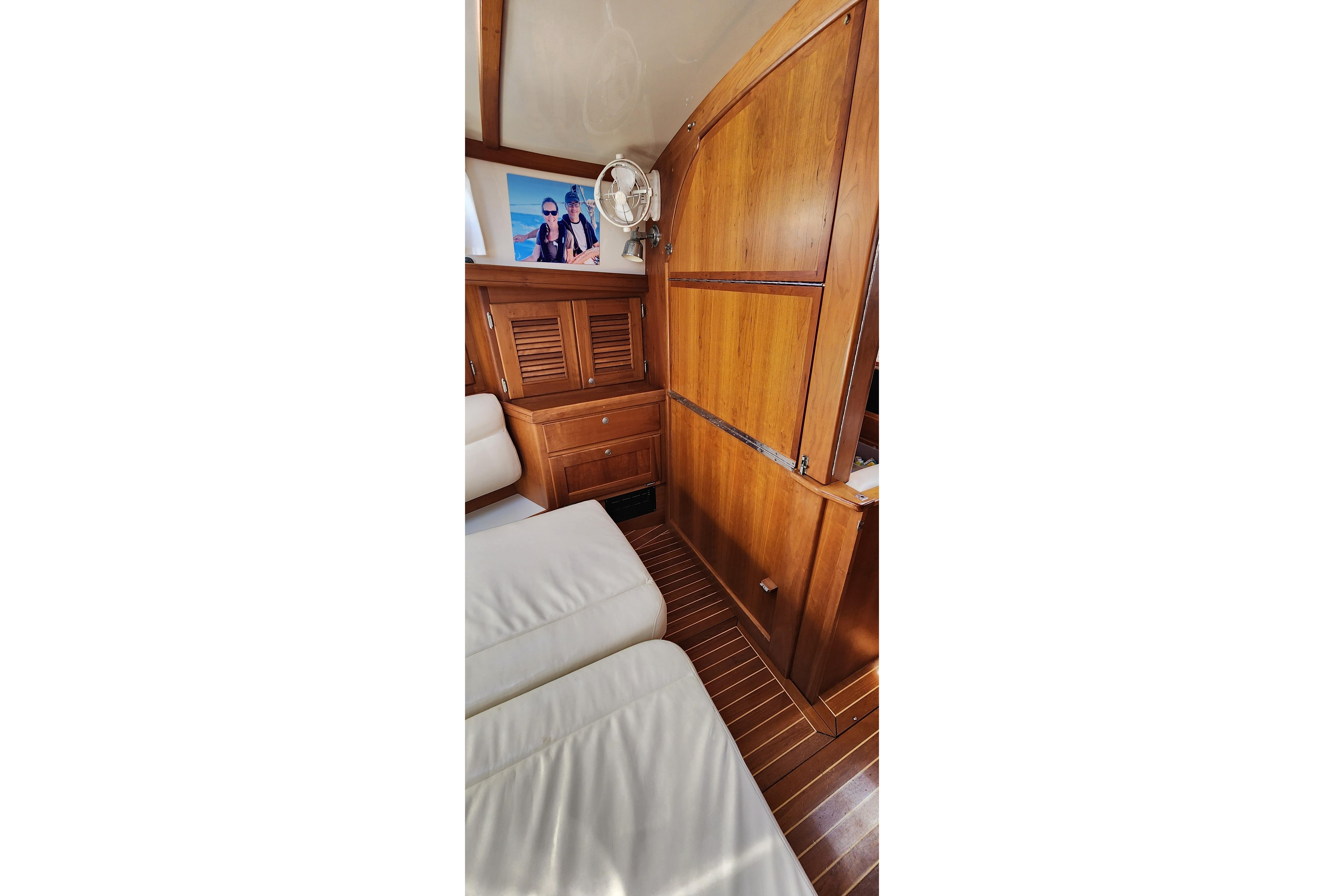 Interior of 1998 Gozzard 36E yacht with wooden cabinetry and white seating.