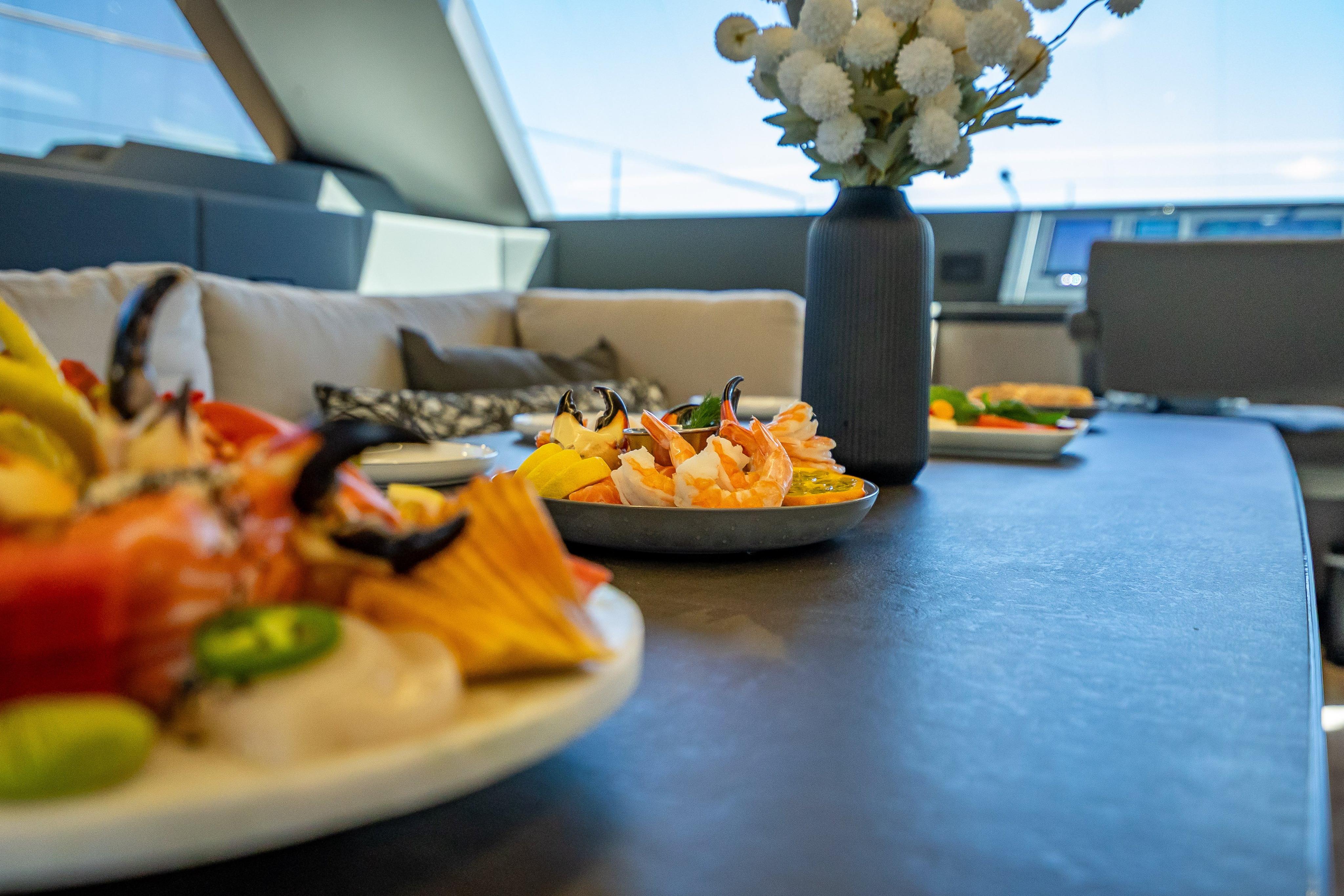 Luxurious dining setup on 2026 Sunreef 60 Power yacht with seafood and elegant decor.