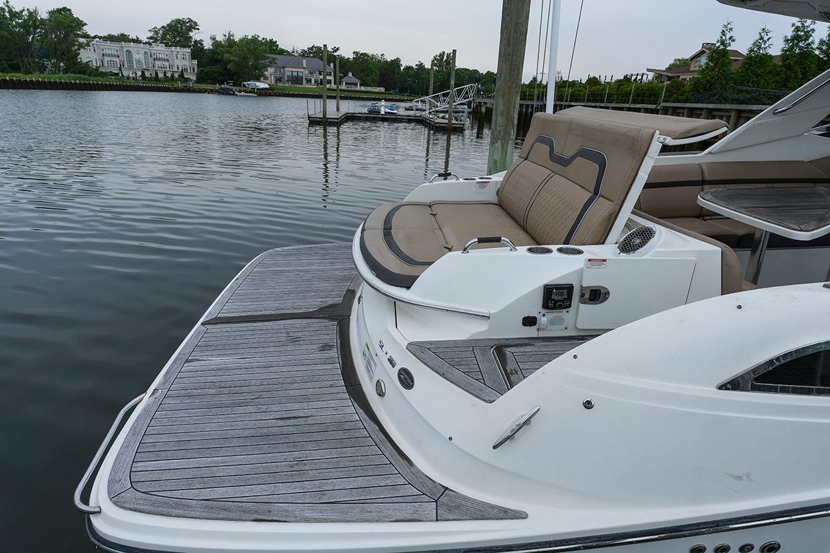 2018 Sea Ray SLX 350 boat with spacious deck and seating, docked by a serene waterfront.