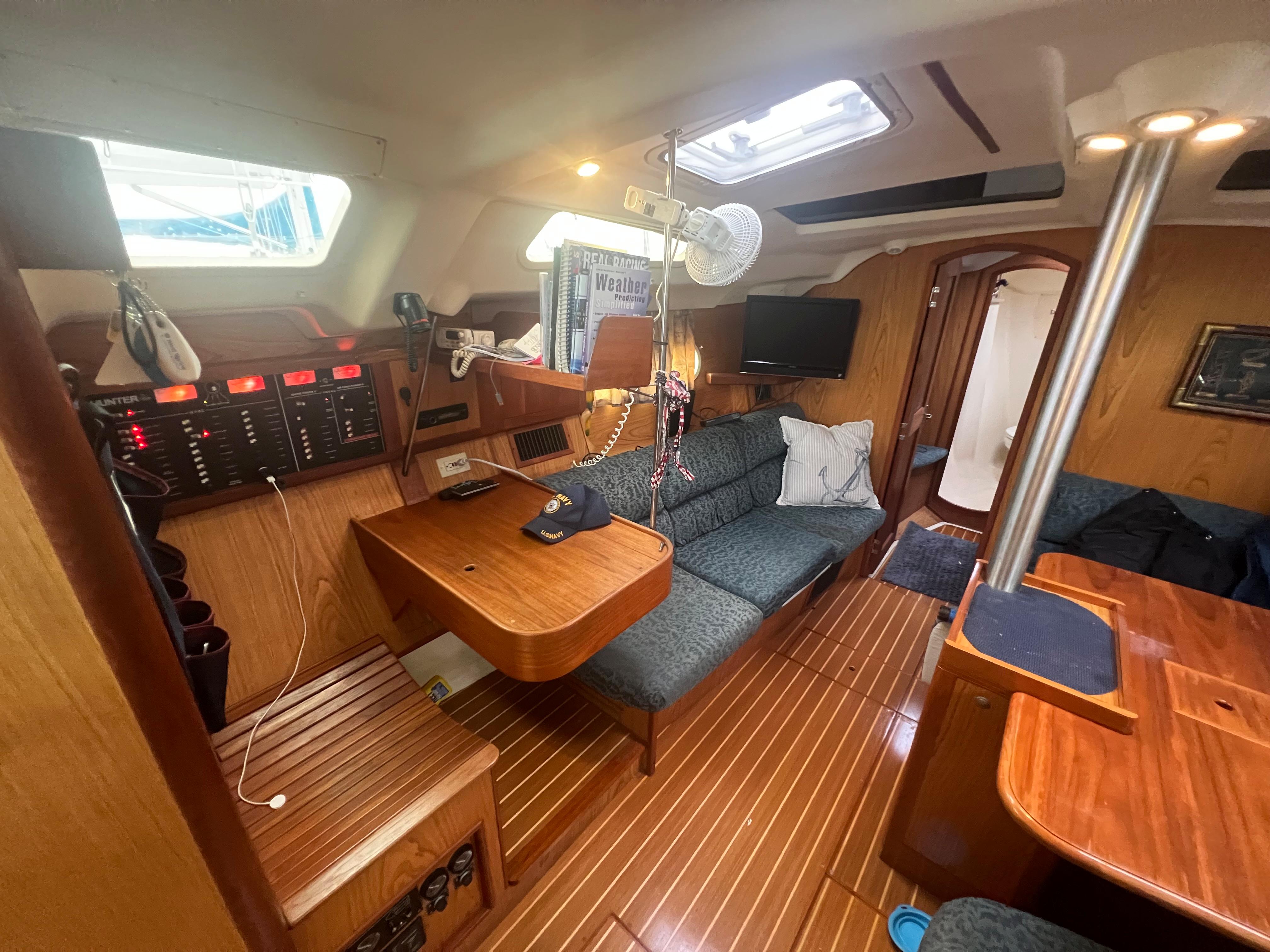 Interior of a 2000 Hunter 410 sailboat with wood finish and cozy seating area.