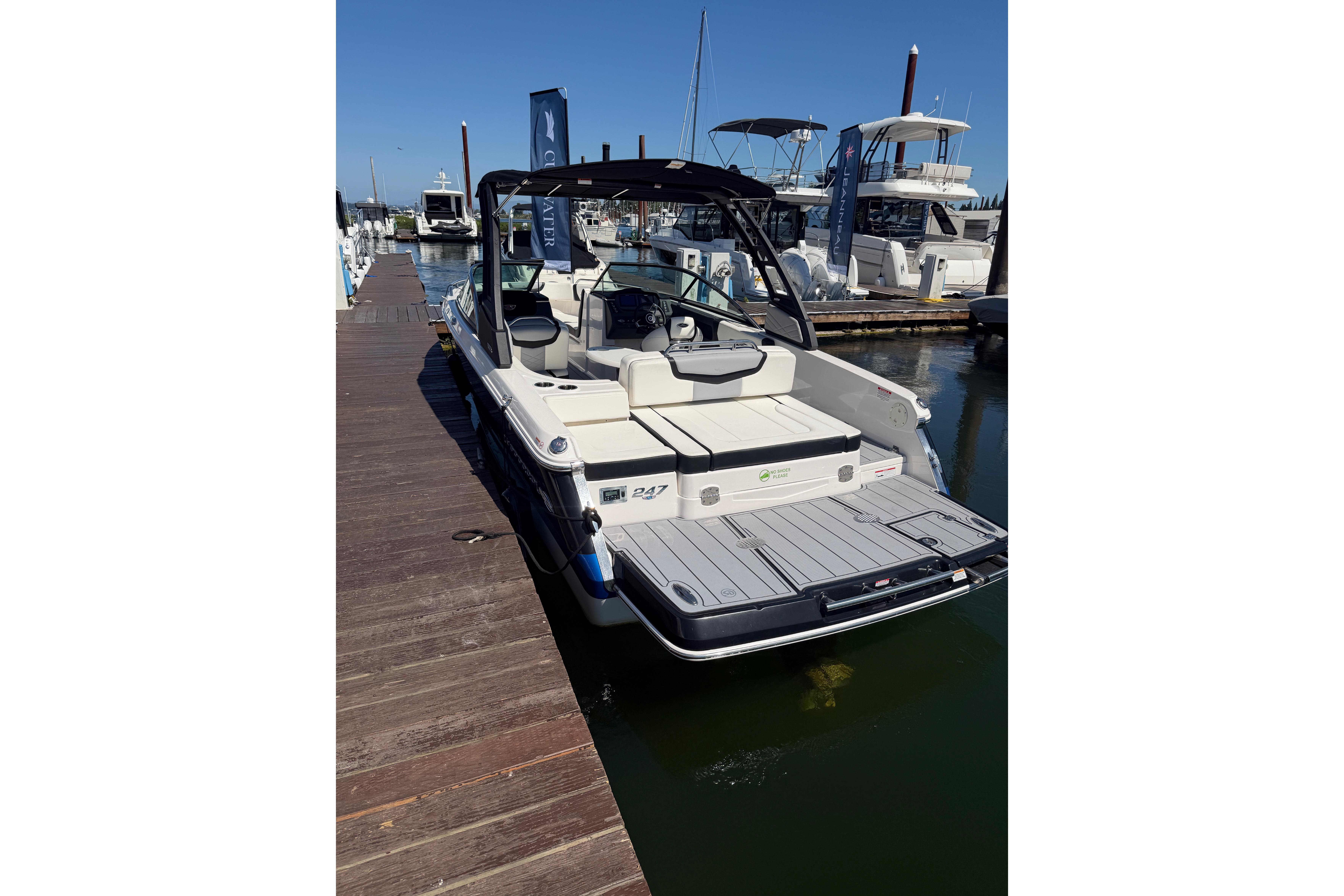 2023 Chaparral 247 SSX boat docked at marina, showcasing sleek design and spacious seating.