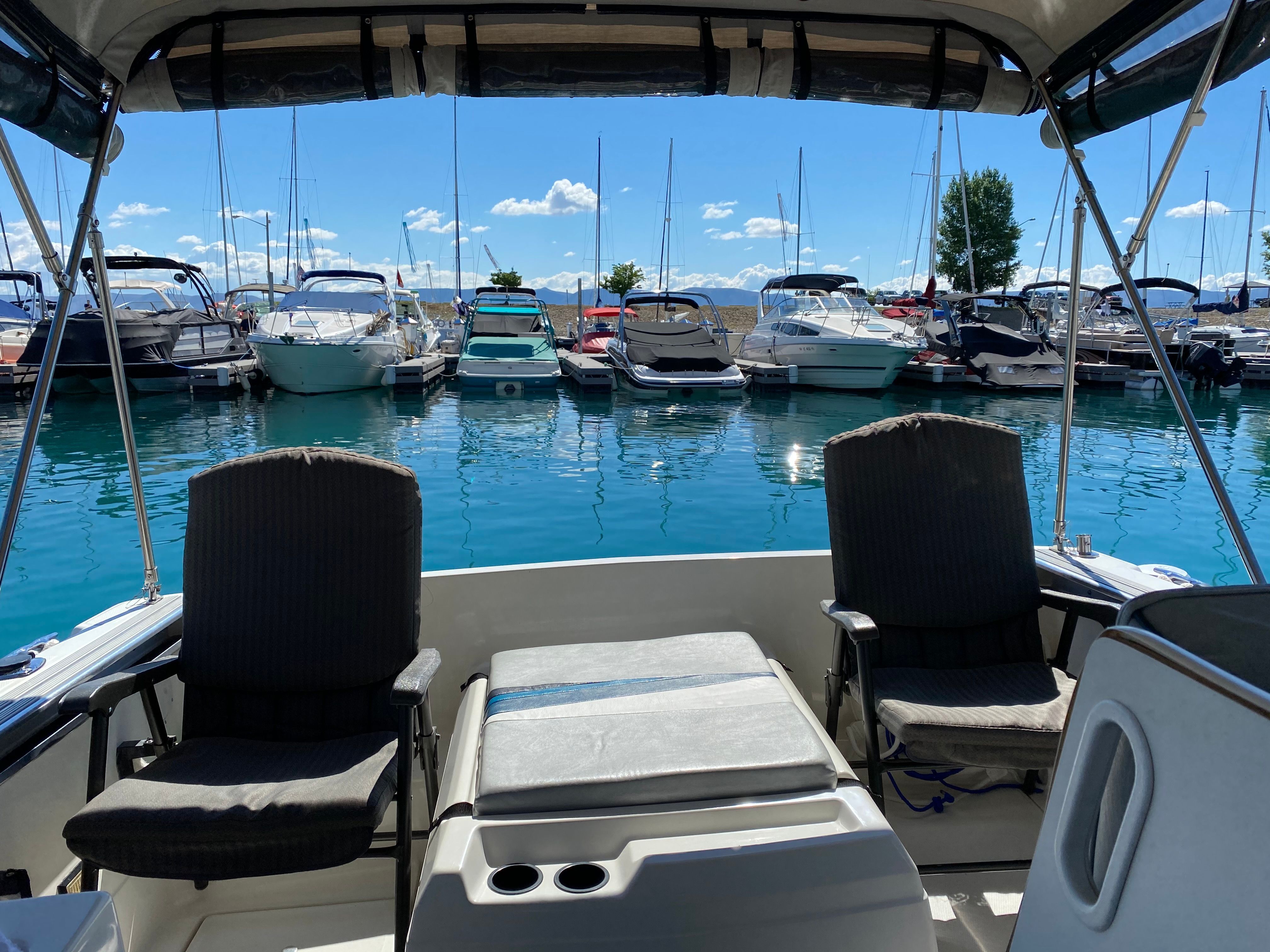 View from inside a Bayliner boat looking out at a marina with several boats on the water.