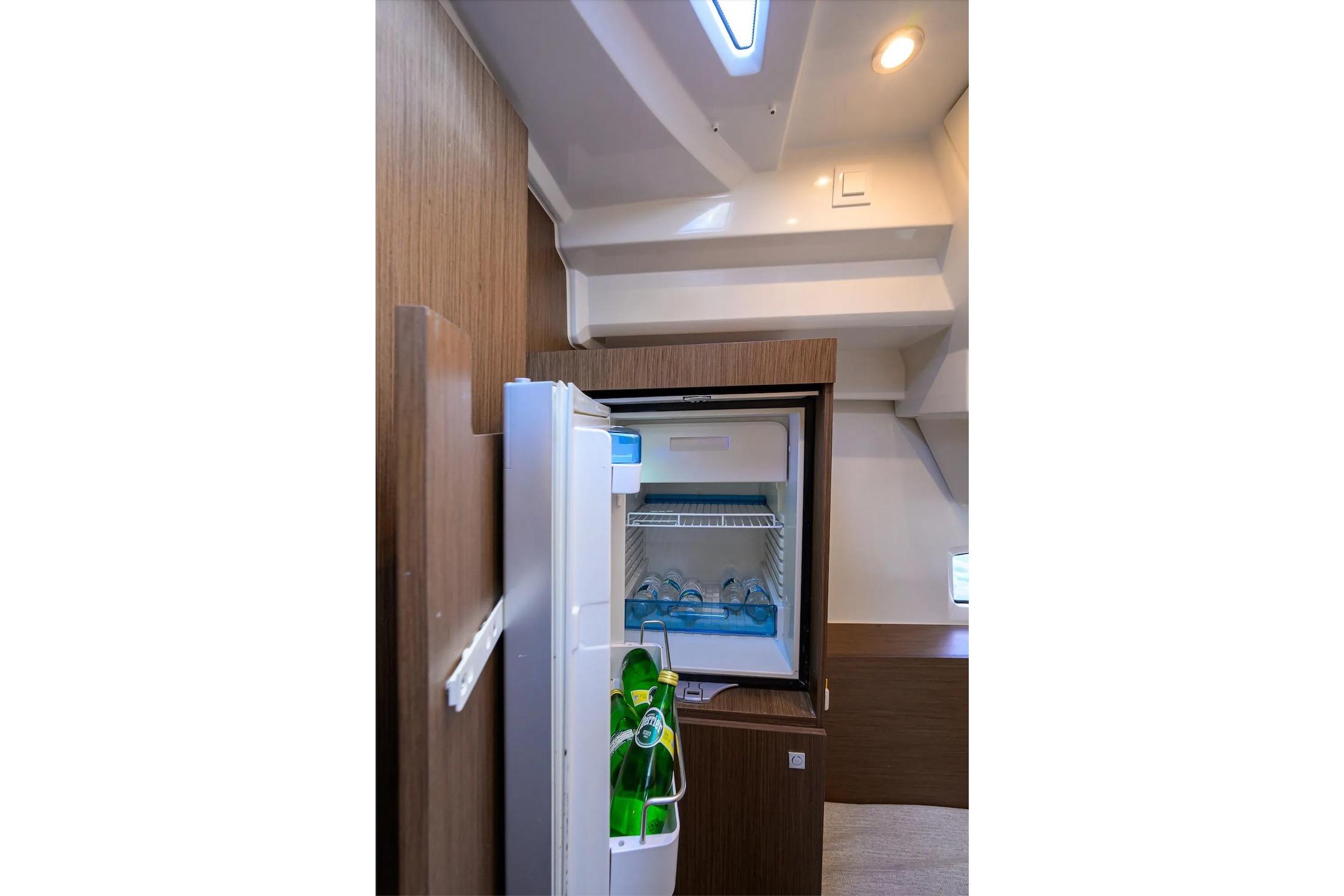 Interior of 2022 Jeanneau NC 1095 Fly yacht with open refrigerator.