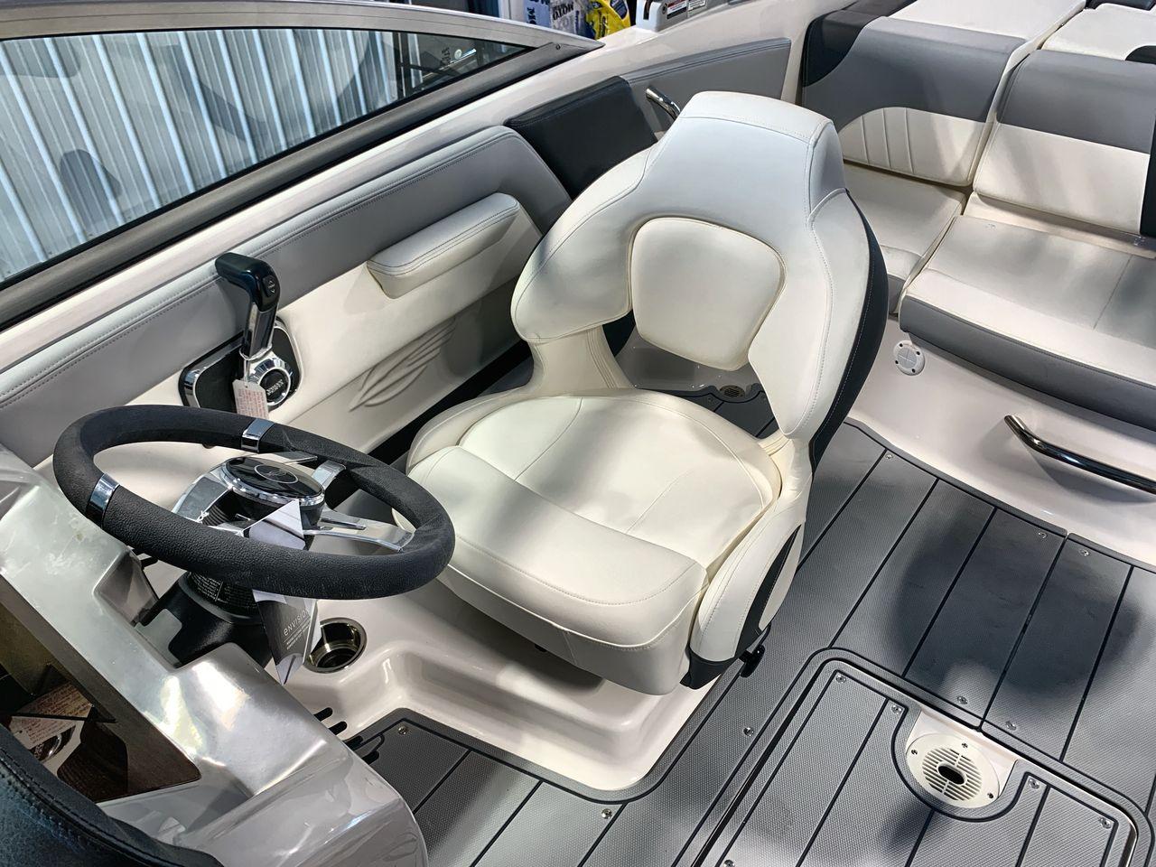 2025 Chaparral 21 SSi boat interior with steering wheel and white captain's chair.