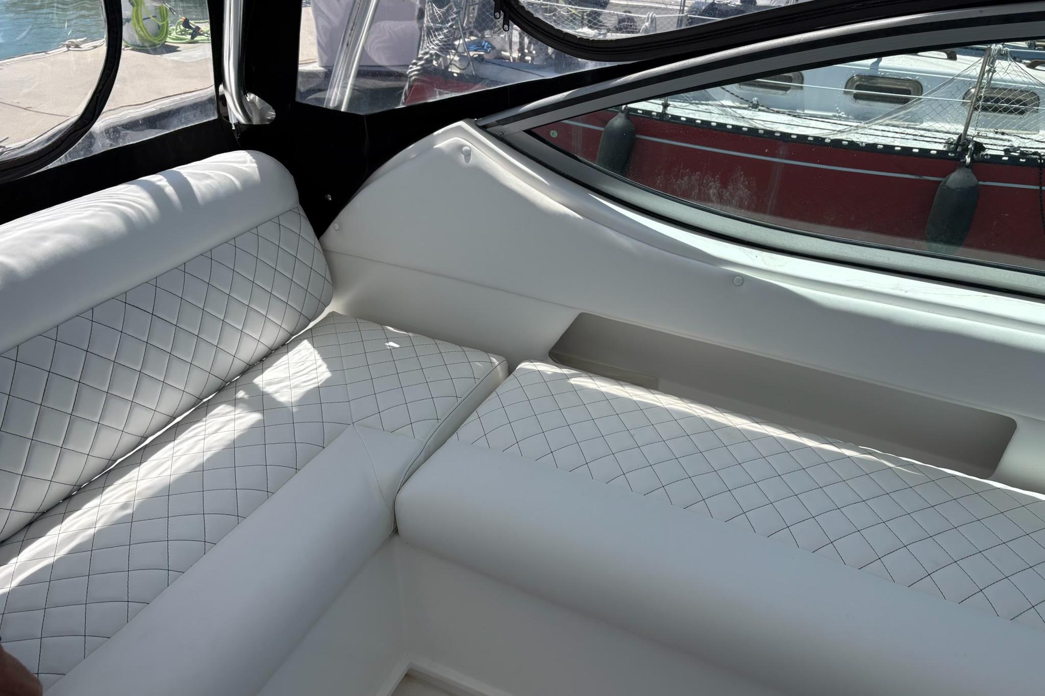 Luxurious white seating inside a 2008 Stamas 370 Express boat, featuring diamond stitching.