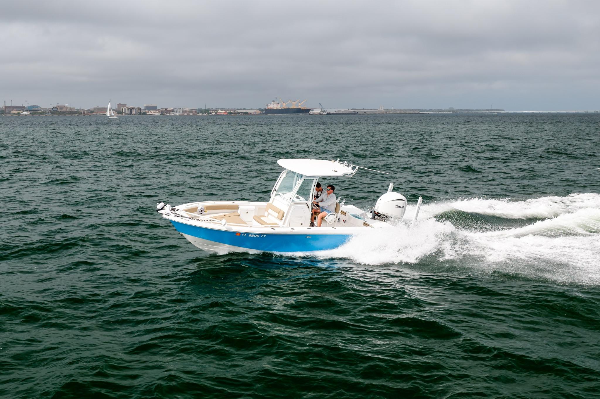 2023 Everglades 243 Center Console boat cruising on open water under cloudy skies.