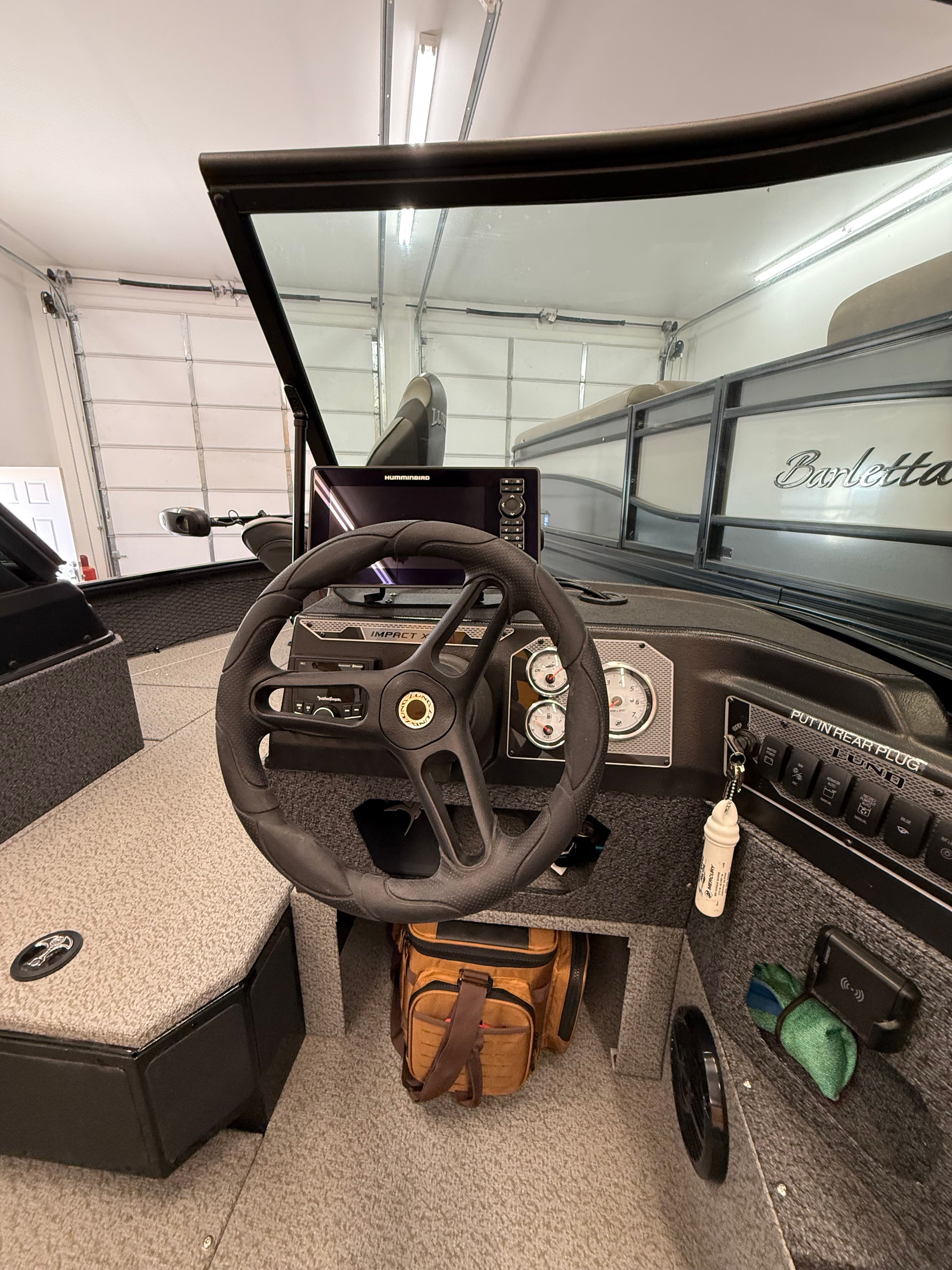 The cockpit of a 2025 Lund 1875 Impact XS Sport with steering wheel and instruments.