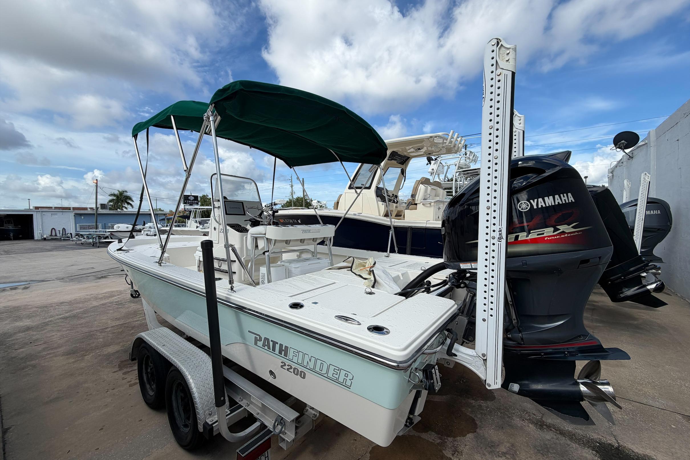 2017 Pathfinder 2200 TRS boat with Yamaha engine, parked on a trailer under a cloudy sky.