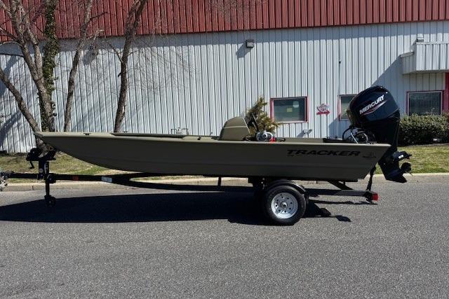 2026 Tracker Grizzly 1648 SC boat on trailer, parked outdoors.