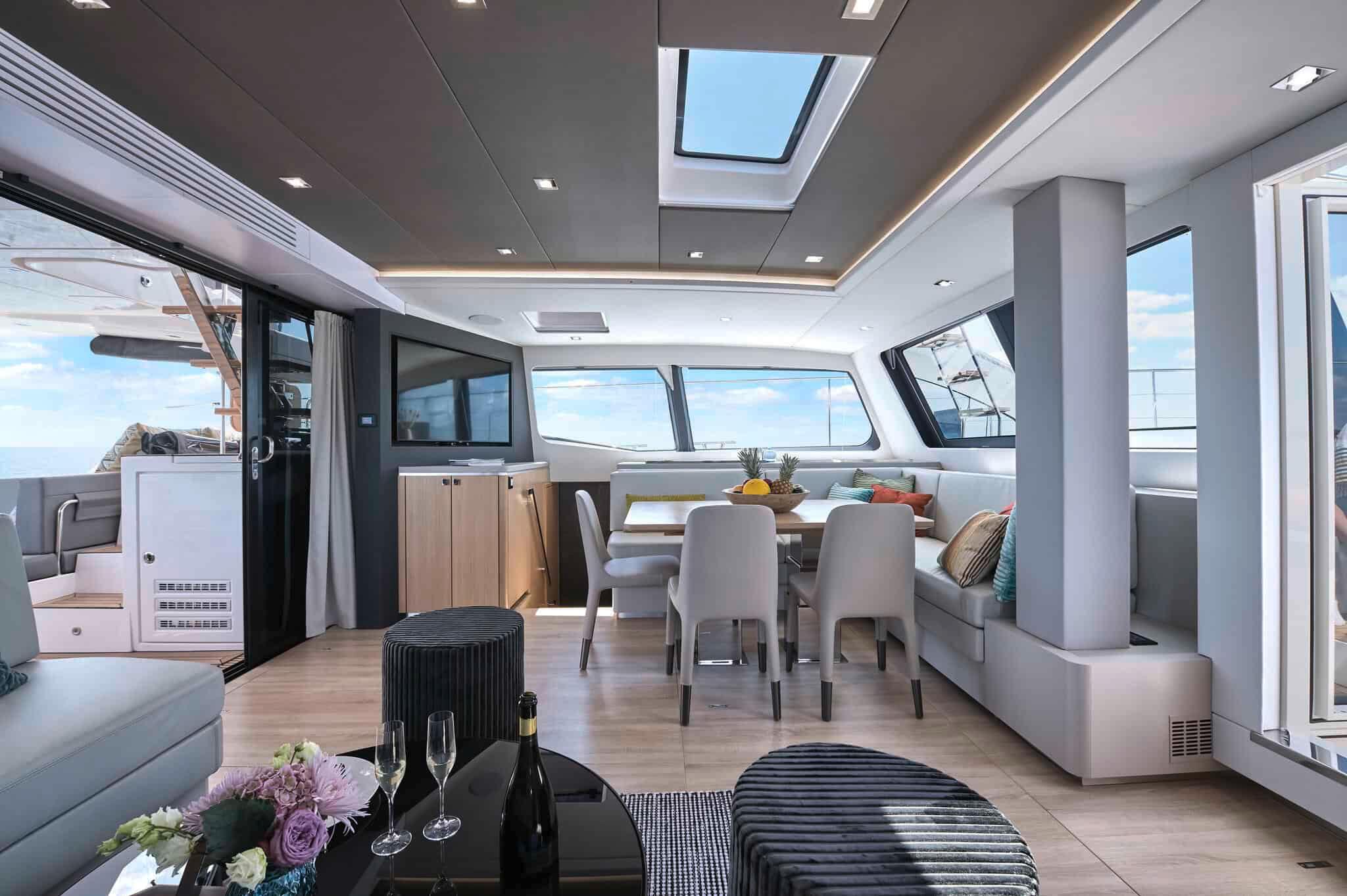 Luxurious interior of 2025 Privilege Signature 580 yacht with modern dining area and panoramic windows.