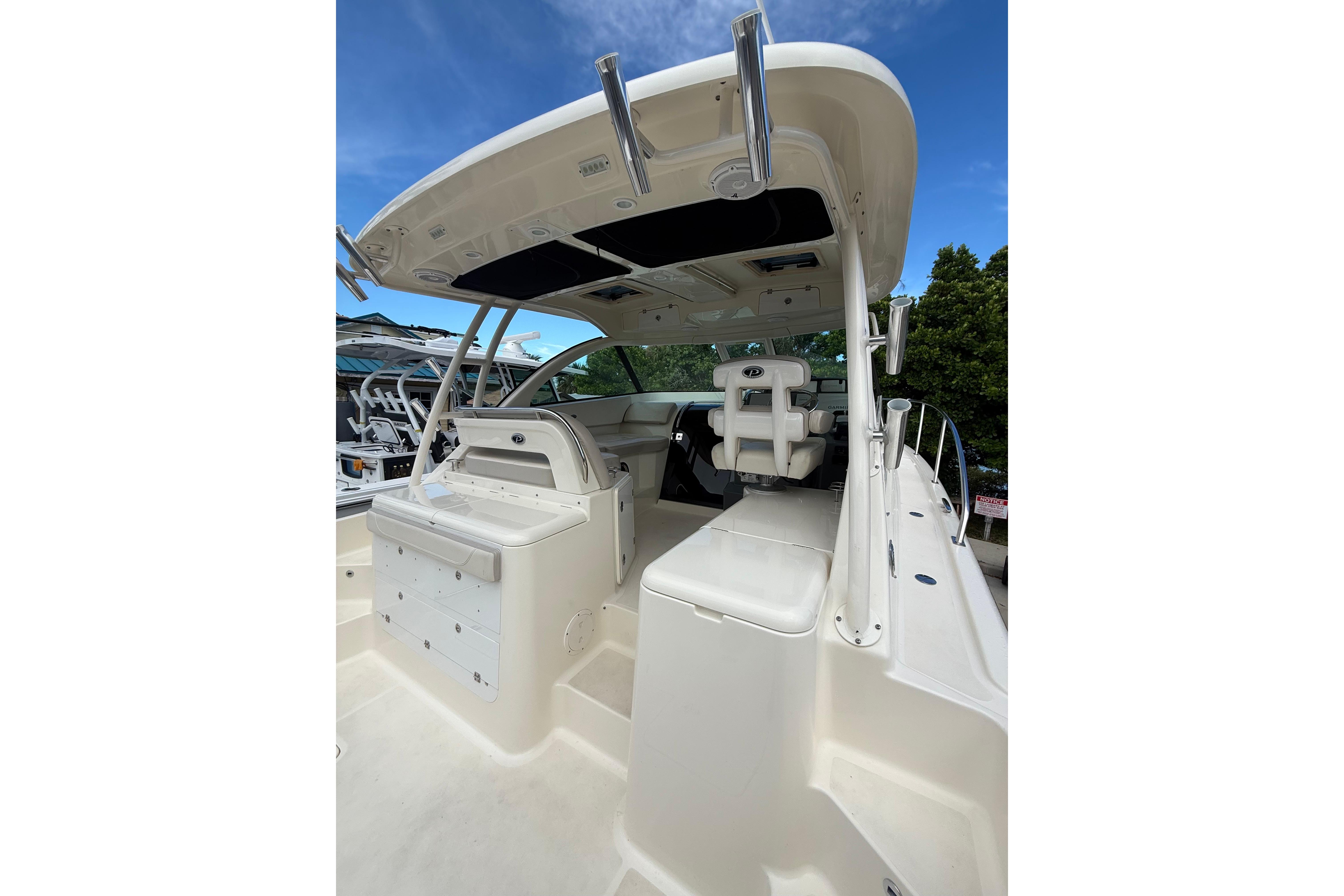 2014 Pursuit OS 345 Offshore boat interior with seating and helm, under a clear blue sky.
