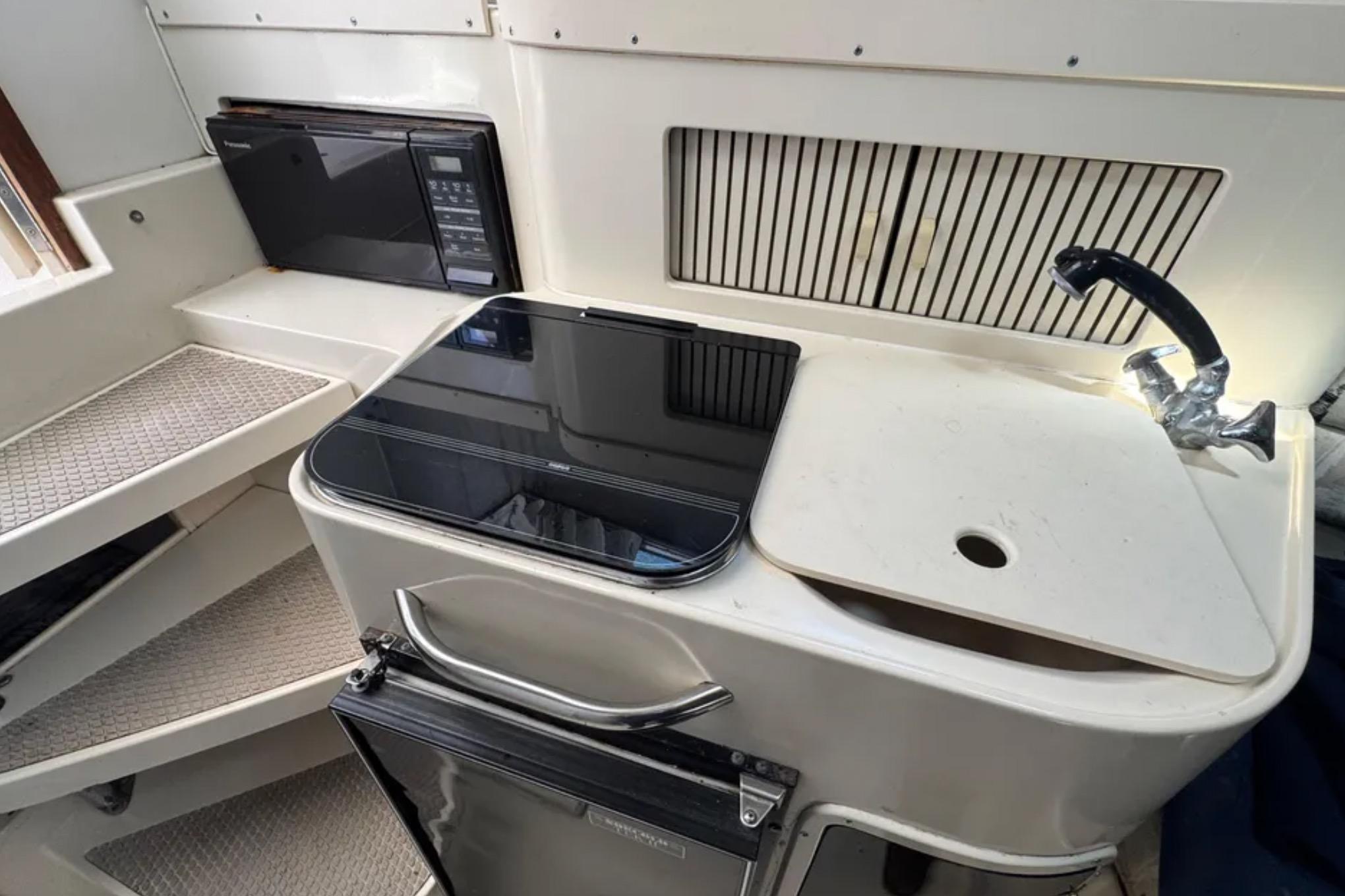 1990 Grady-White Marlin 280 boat interior with kitchenette, sink, and microwave.
