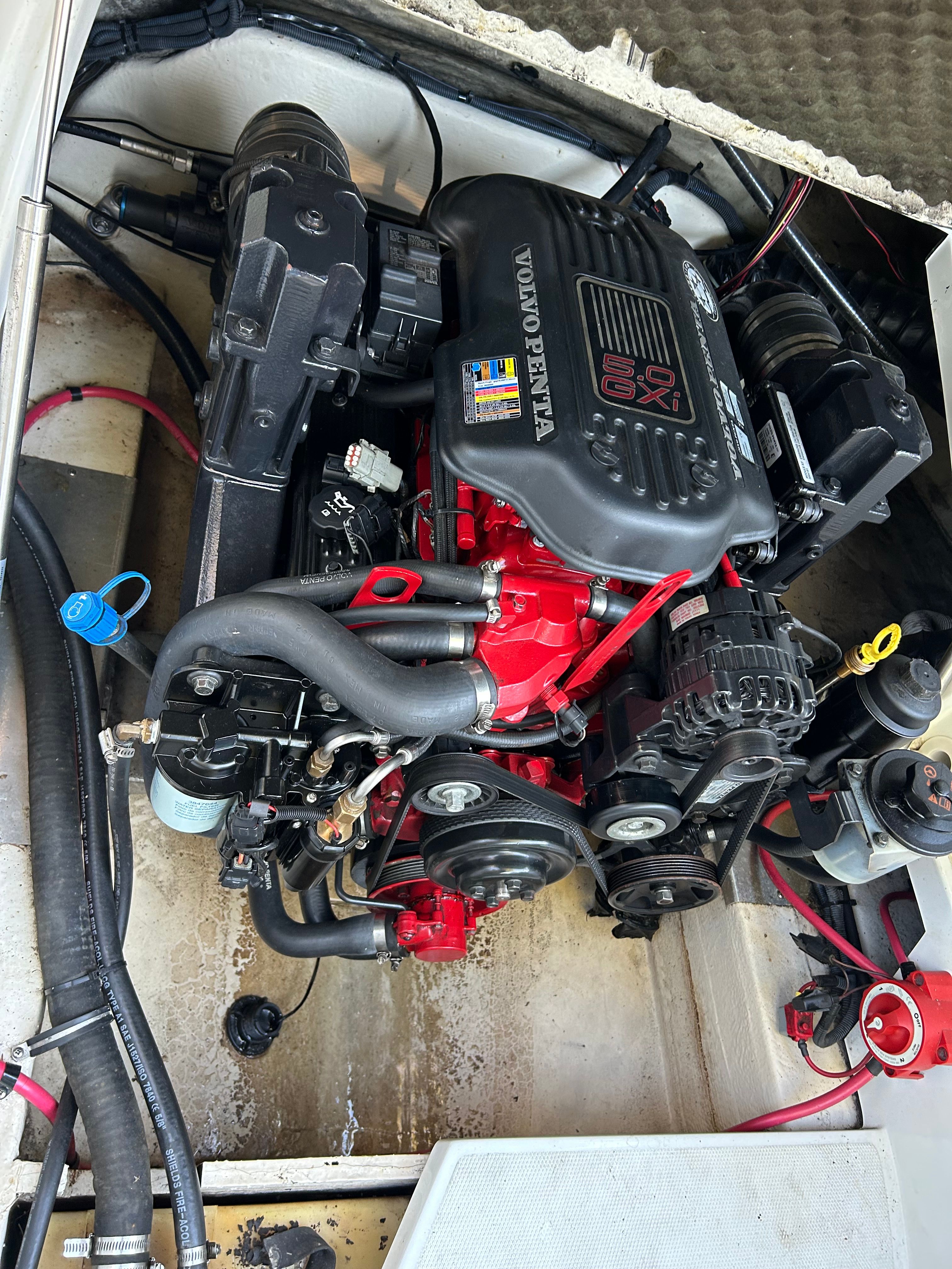 A Volvo Penta engine in a boat, surrounded by cables and hoses.