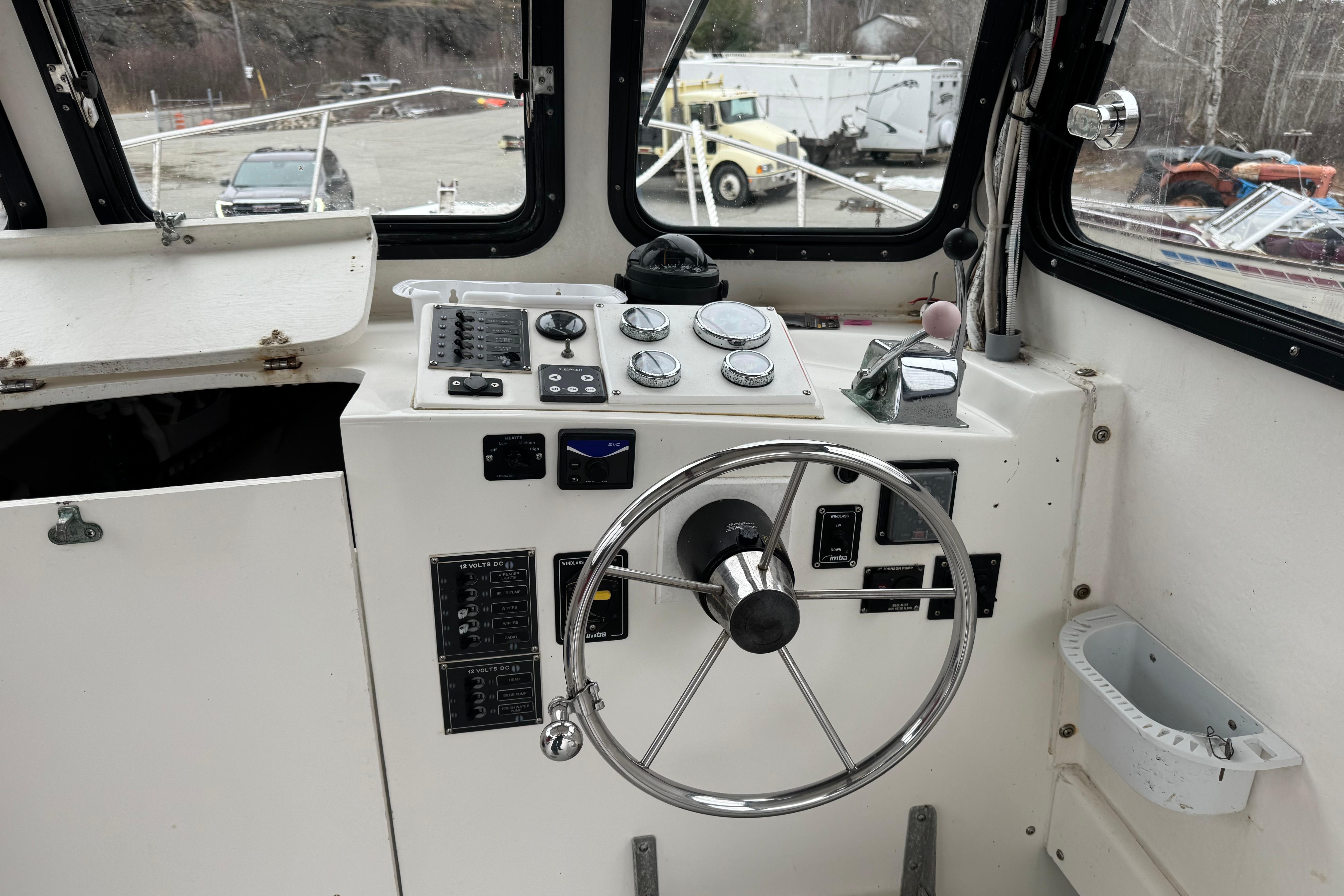 Interior view of a 2001 Eastern Lobsterman 27 boat cockpit with steering wheel and controls.