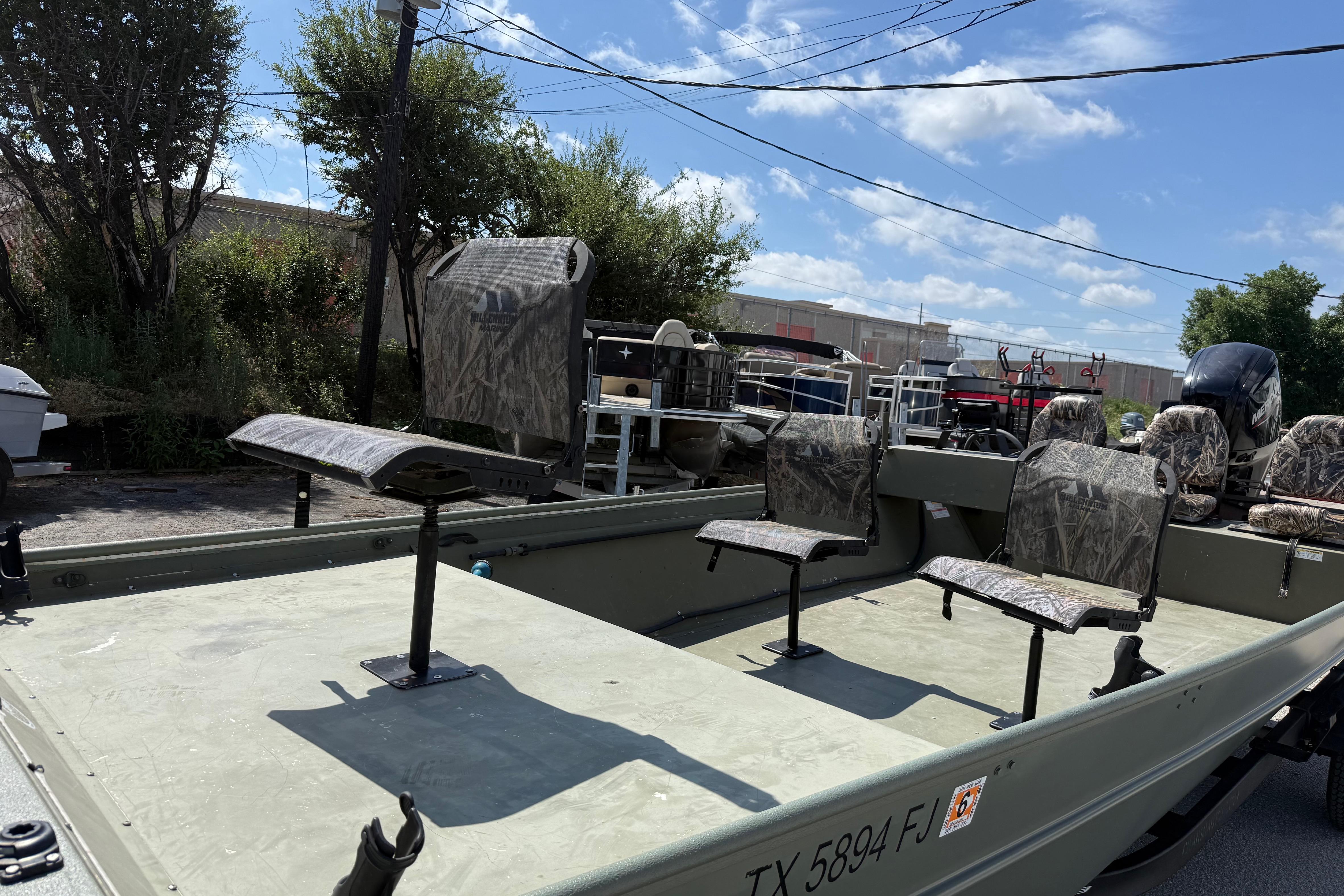 A 2020 Lowe Roughneck 2070 Big River boat with camouflage seats, parked on a trailer.