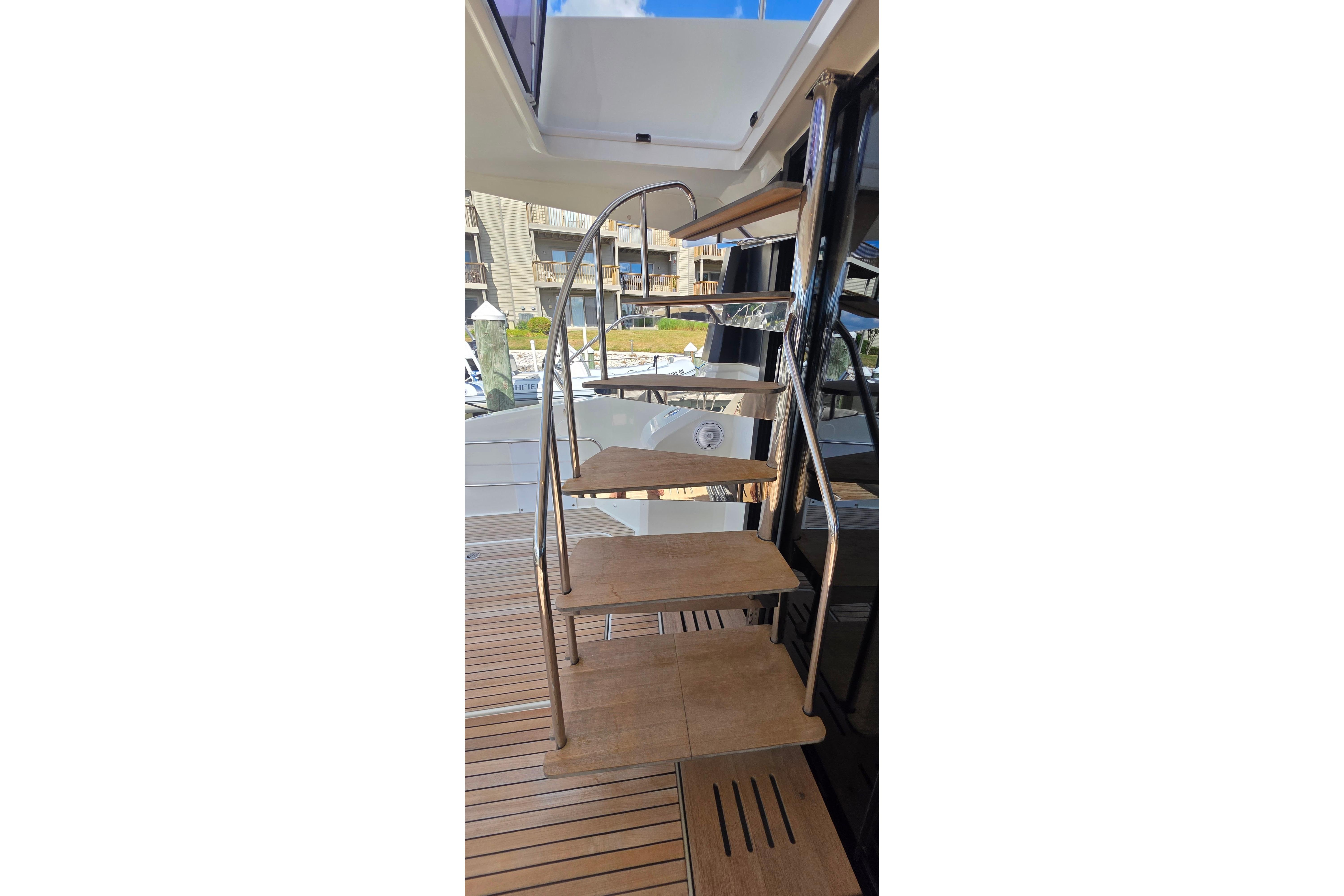 Staircase on 2018 Fountaine Pajot Motor Yacht 44 with wooden steps and metal railing.