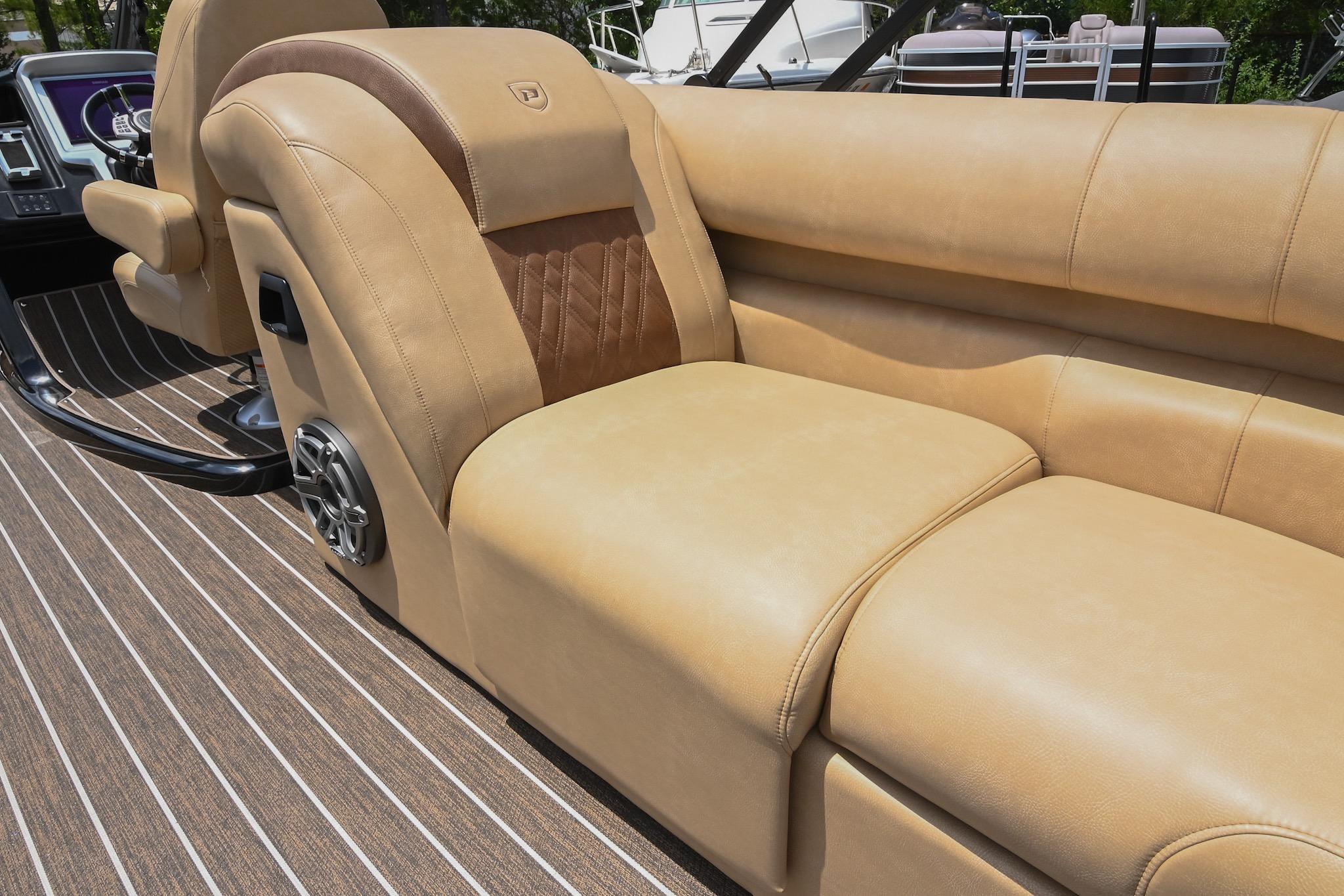 Luxurious seating on 2023 Premier 270 Intrigue RF boat with tan upholstery and speaker system.