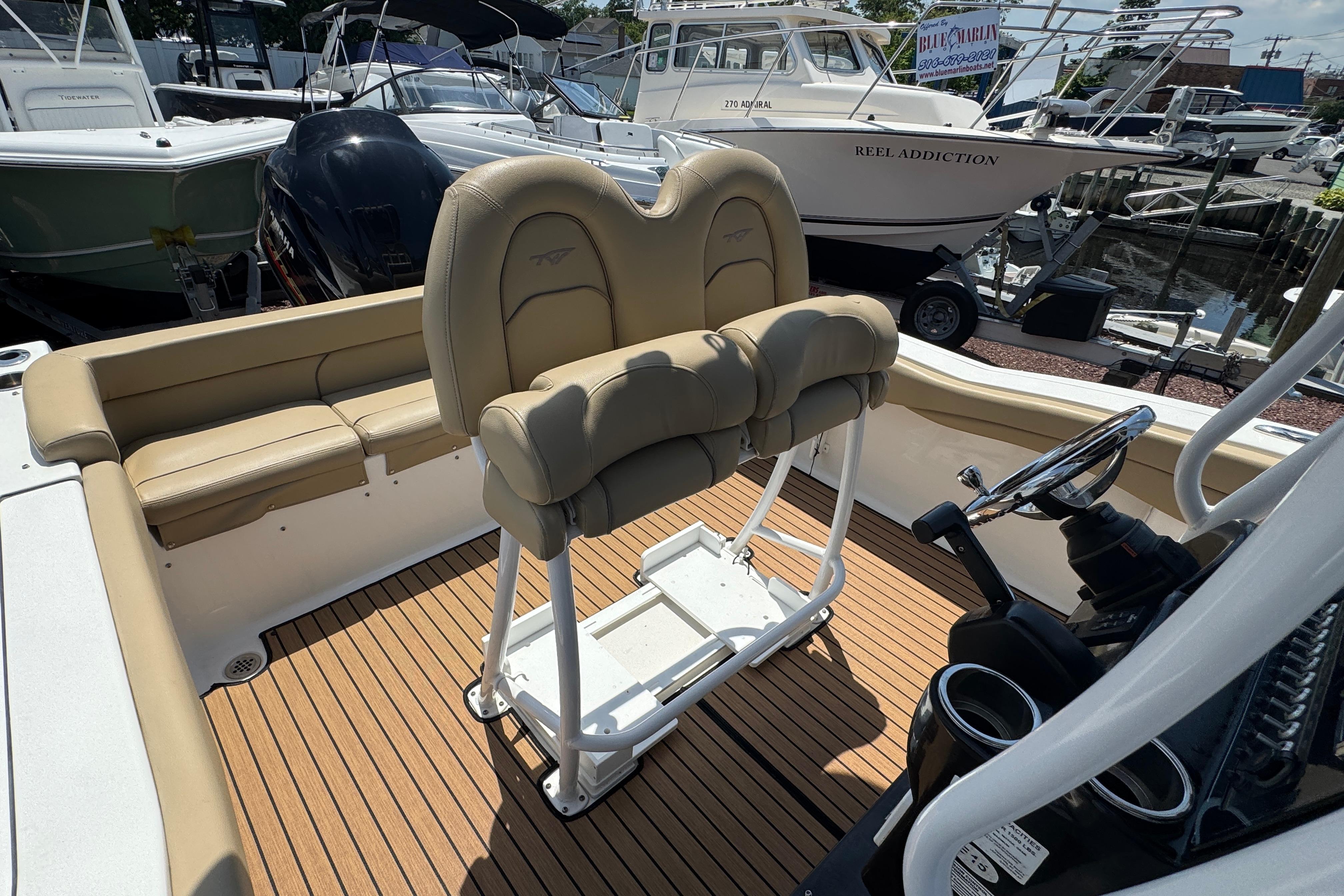2016 Tidewater 230 LXF boat interior with tan seating and wood-style flooring.