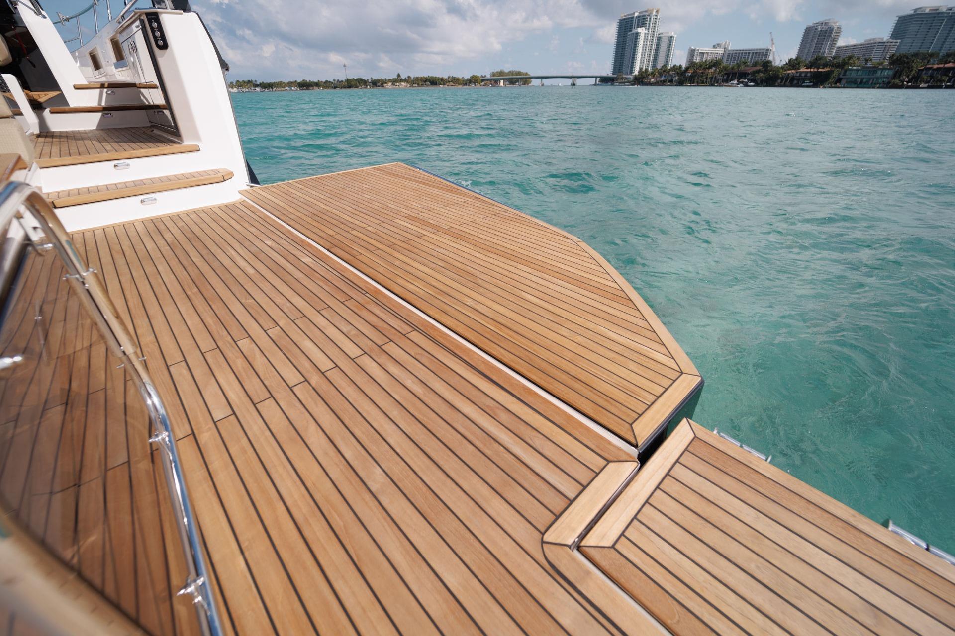 Luxurious Hanover 447 yacht deck, 2026 model, overlooking turquoise waters and city skyline.