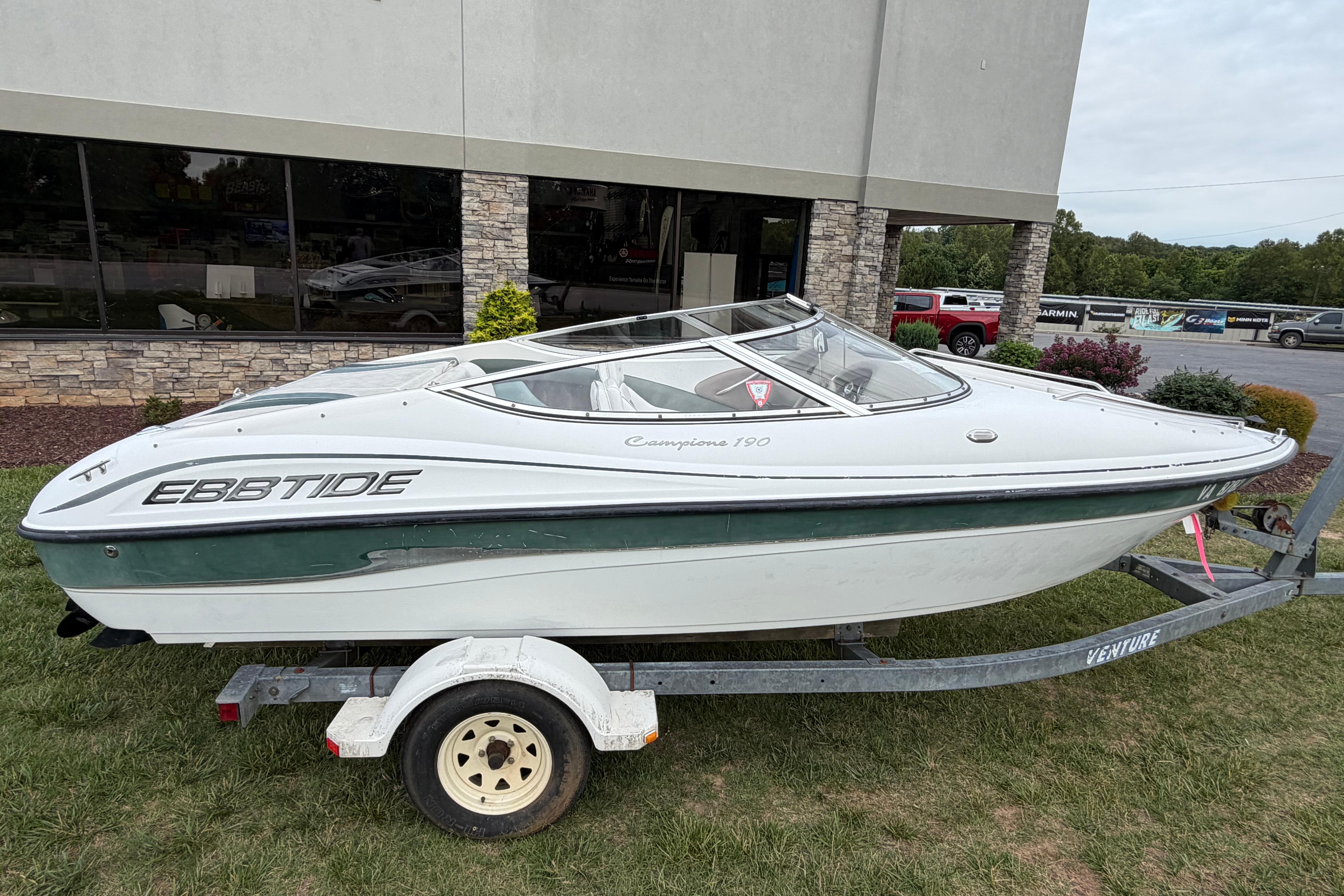 2001 Ebbtide Campione 190 boat on trailer, parked outdoors near a building.