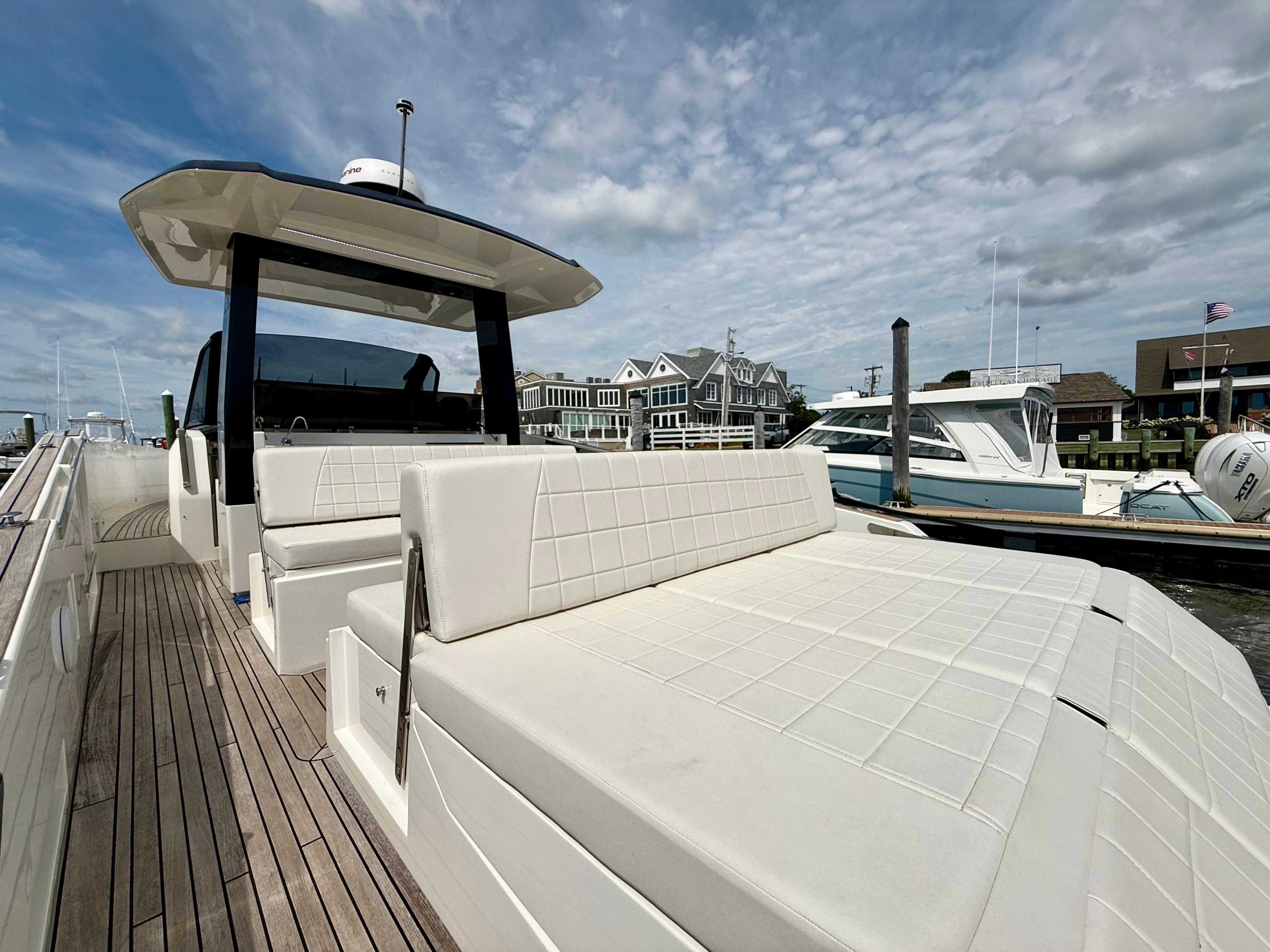 2023 Astondoa 377 Coupe Outboard yacht with sleek design, docked at marina under cloudy sky.