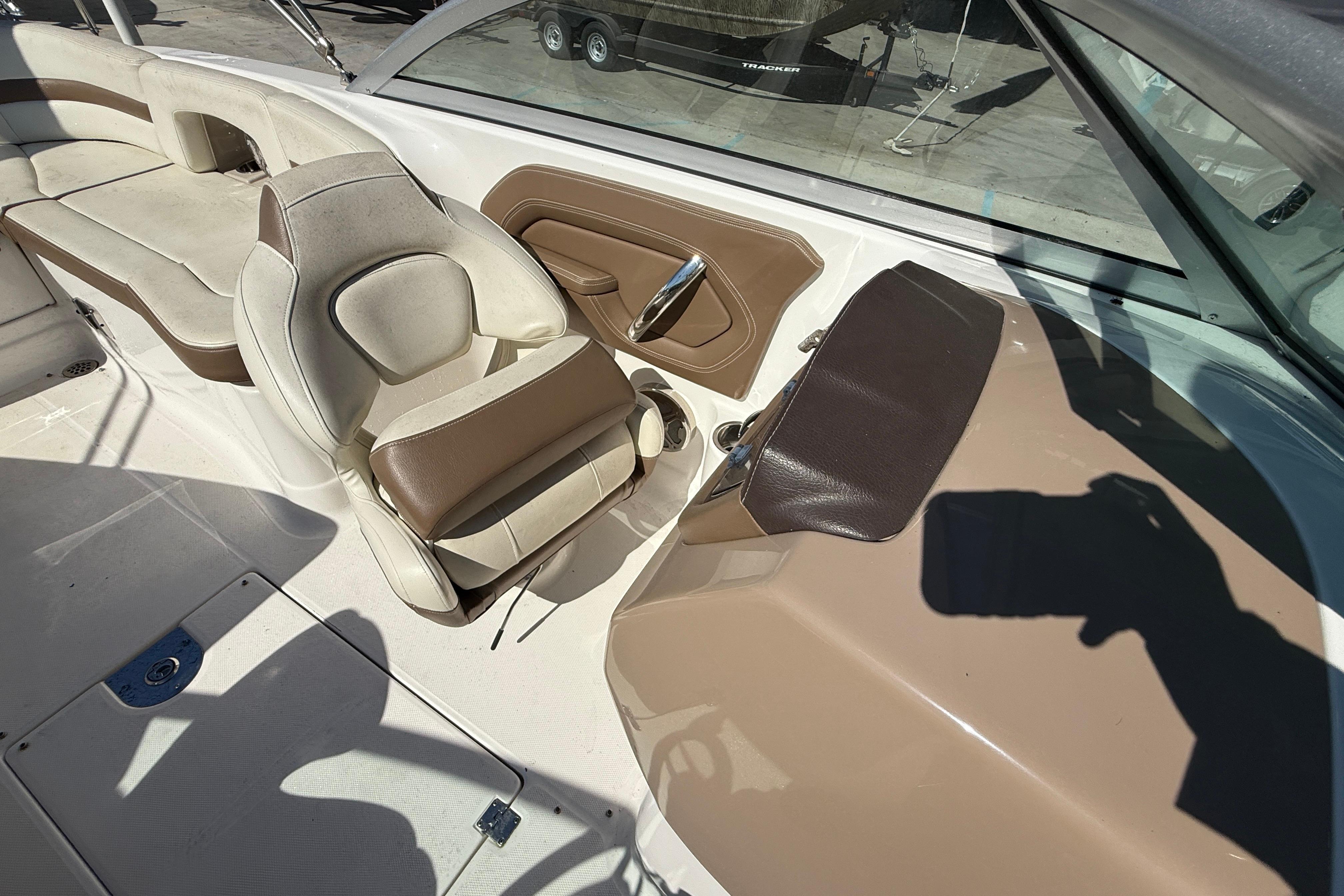 2014 Chaparral 264 Sunesta boat interior with beige and brown seating and steering area.