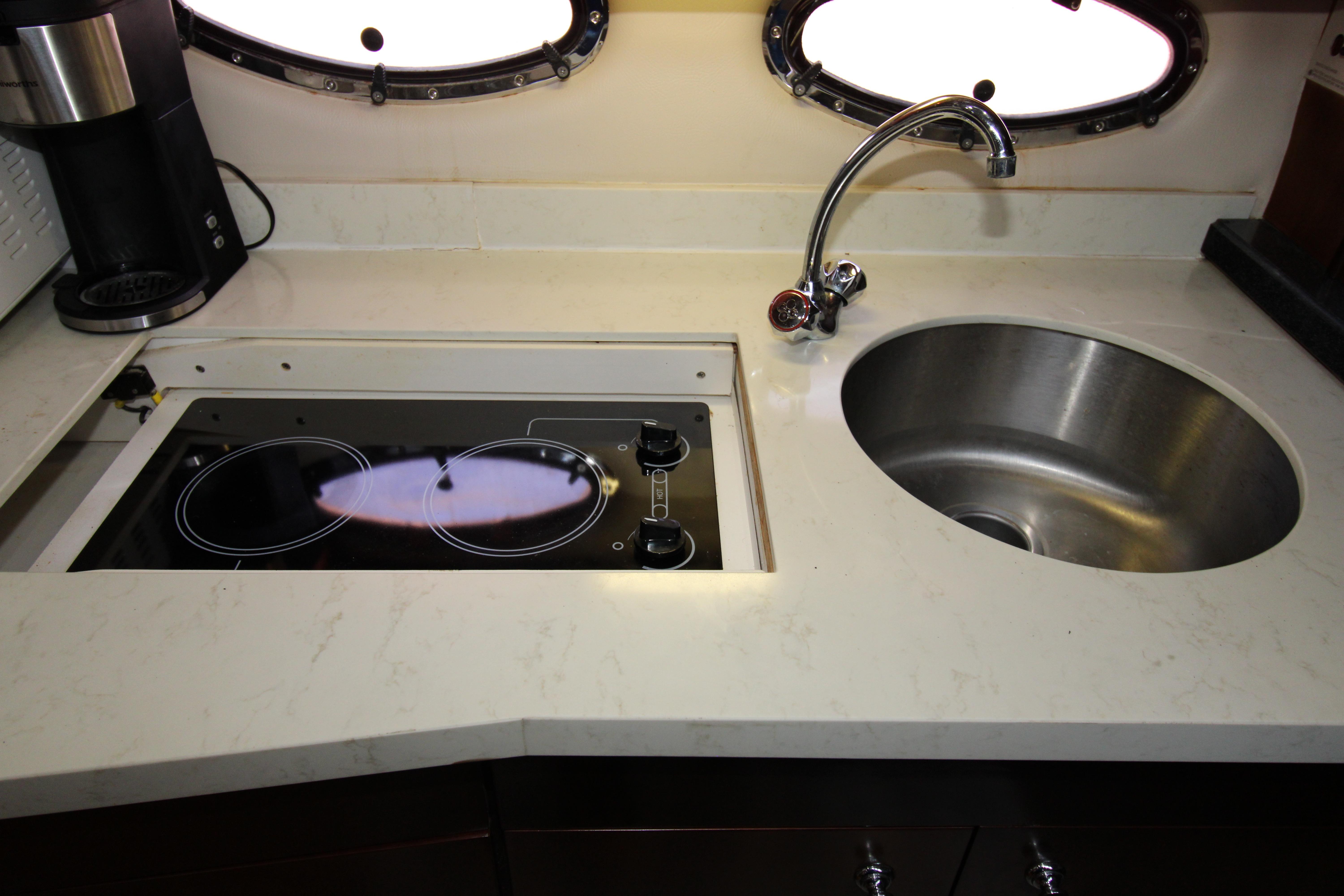2002 Regal Commodore 4260 yacht kitchen with stove, sink, and coffee maker.