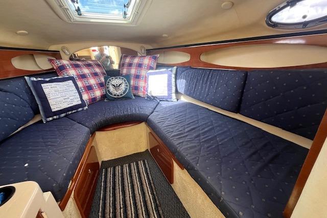 Interior of 2003 Sea Ray 260 Sundancer with blue seating and decorative pillows.