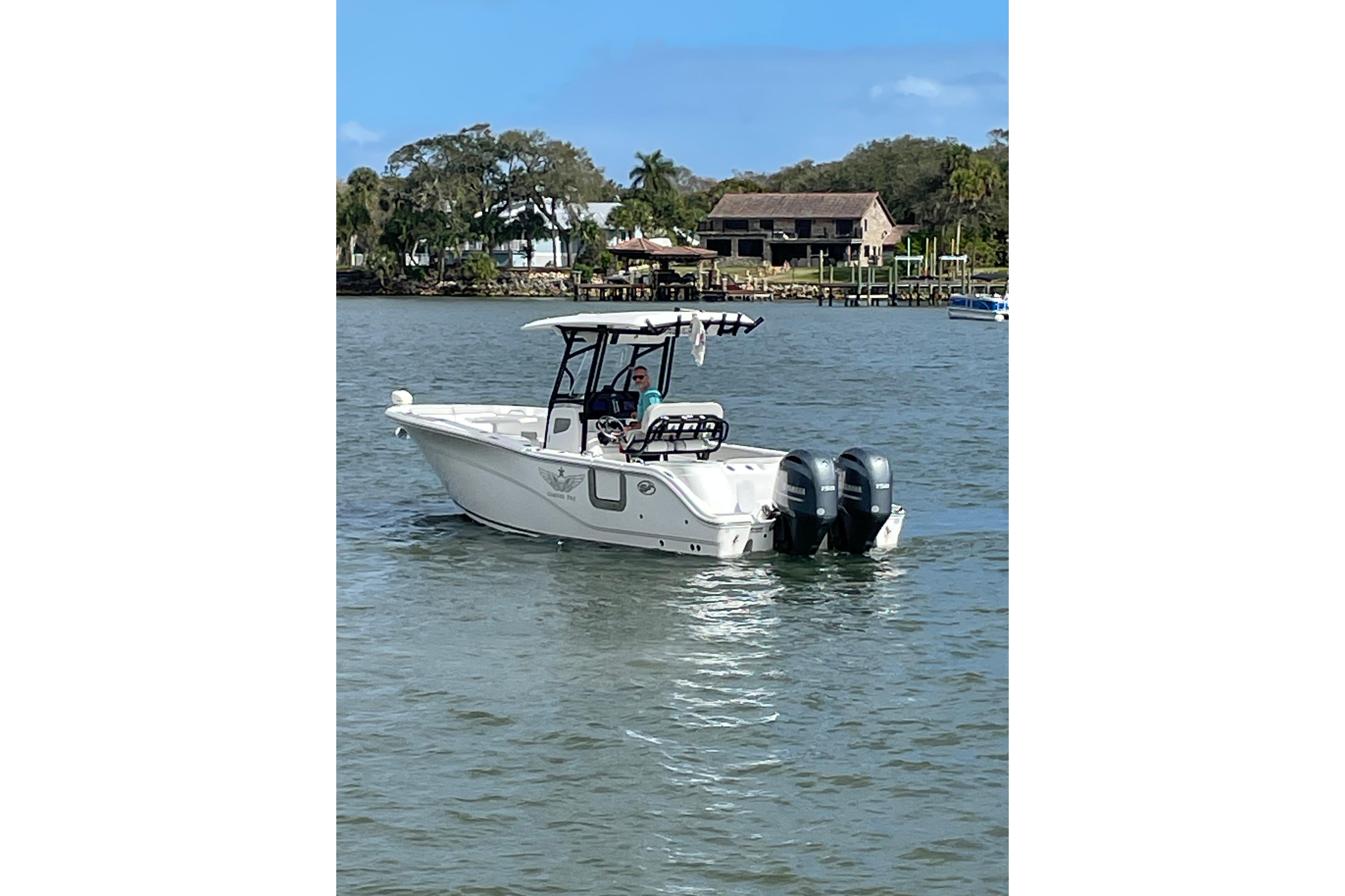 2023 Sea Fox 268 Commander boat cruising on a calm river with scenic background.